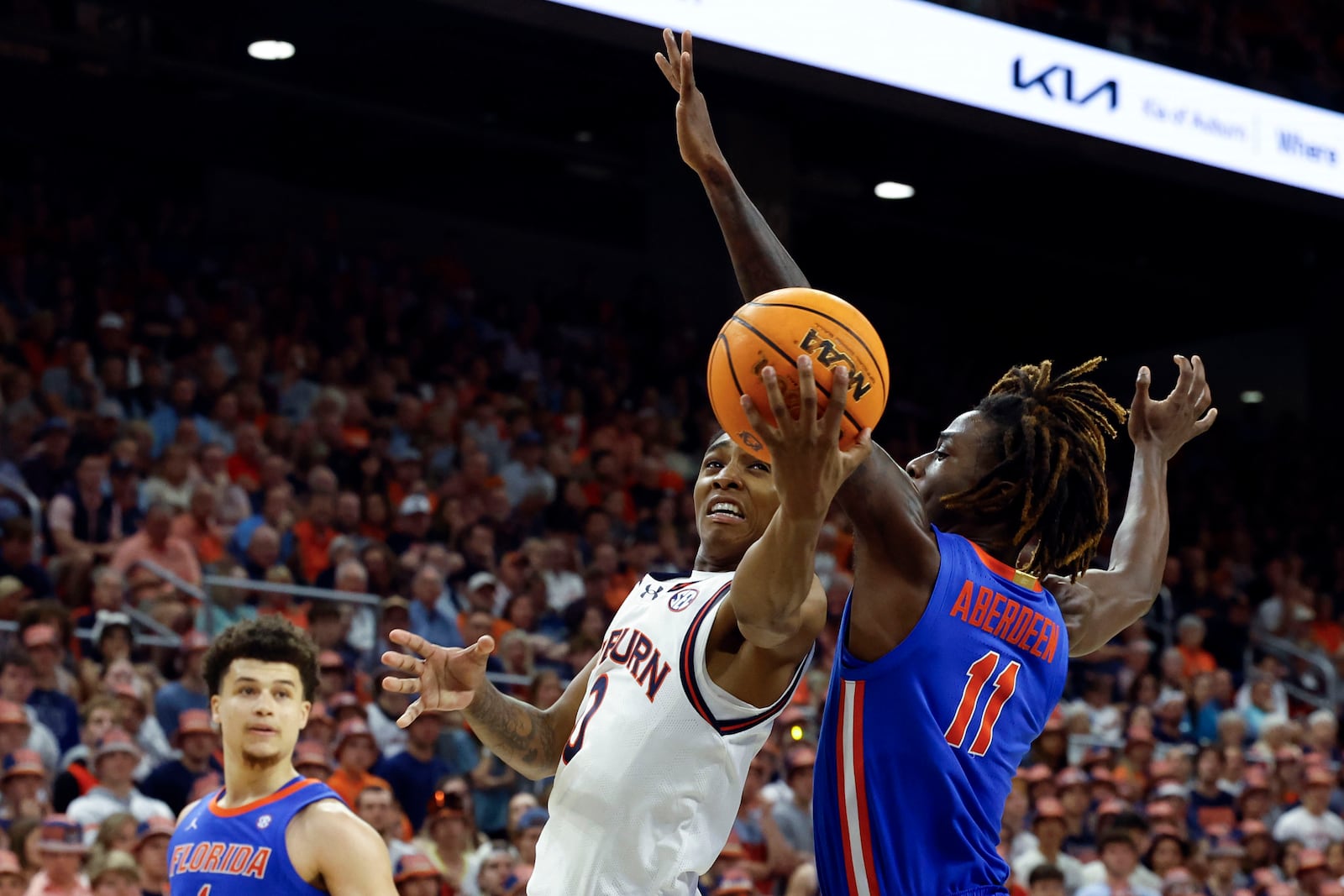 Auburn guard Tahaad Pettiford (0) is fouled by Florida guard Denzel Aberdeen (11) as he shoots during the second half of an NCAA college basketball game, Saturday, Feb. 8, 2025, in Auburn, Ala. (AP Photo/Butch Dill)