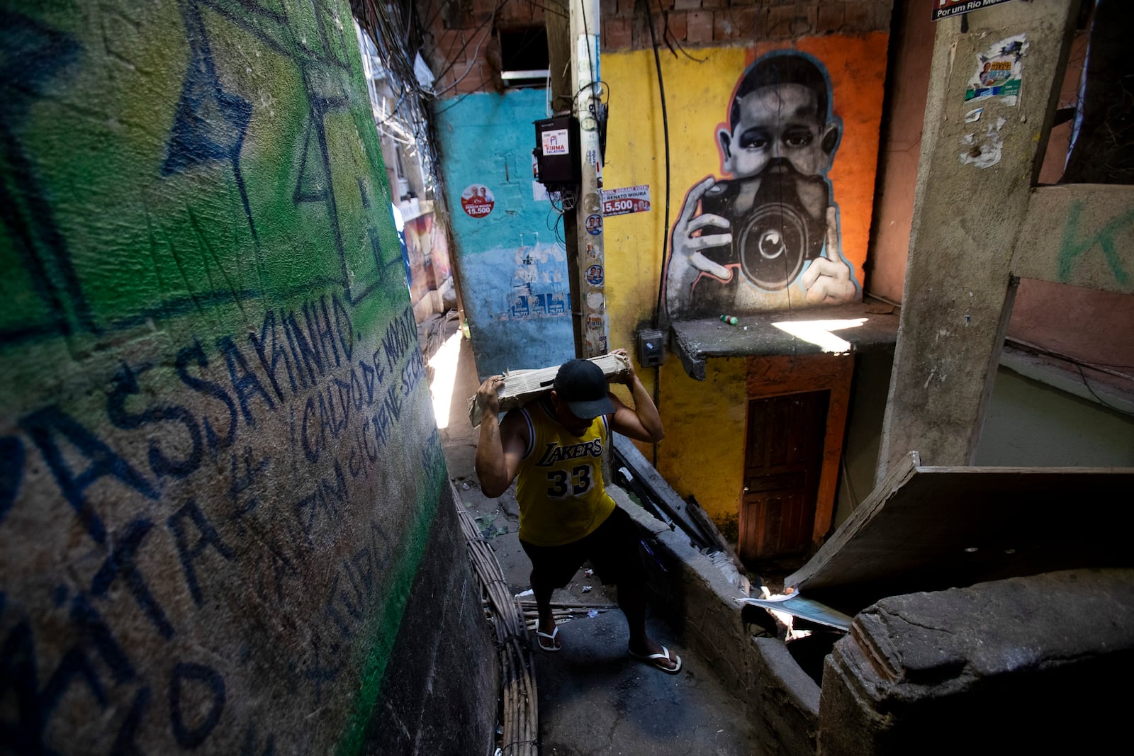 A local carries building materials up an alley in the Rocinha favela of Rio de Janeiro, Wednesday, Nov. 6, 2024. (AP Photo/Bruna Prado)