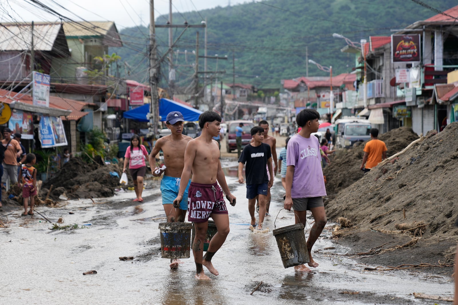 Residents clear out mud from their homes after a recent landslide triggered by Tropical Storm Trami struck Talisay, Batangas province, Philippines leaving thousands homeless and several villagers dead on Saturday, Oct. 26, 2024. (AP Photo/Aaron Favila)