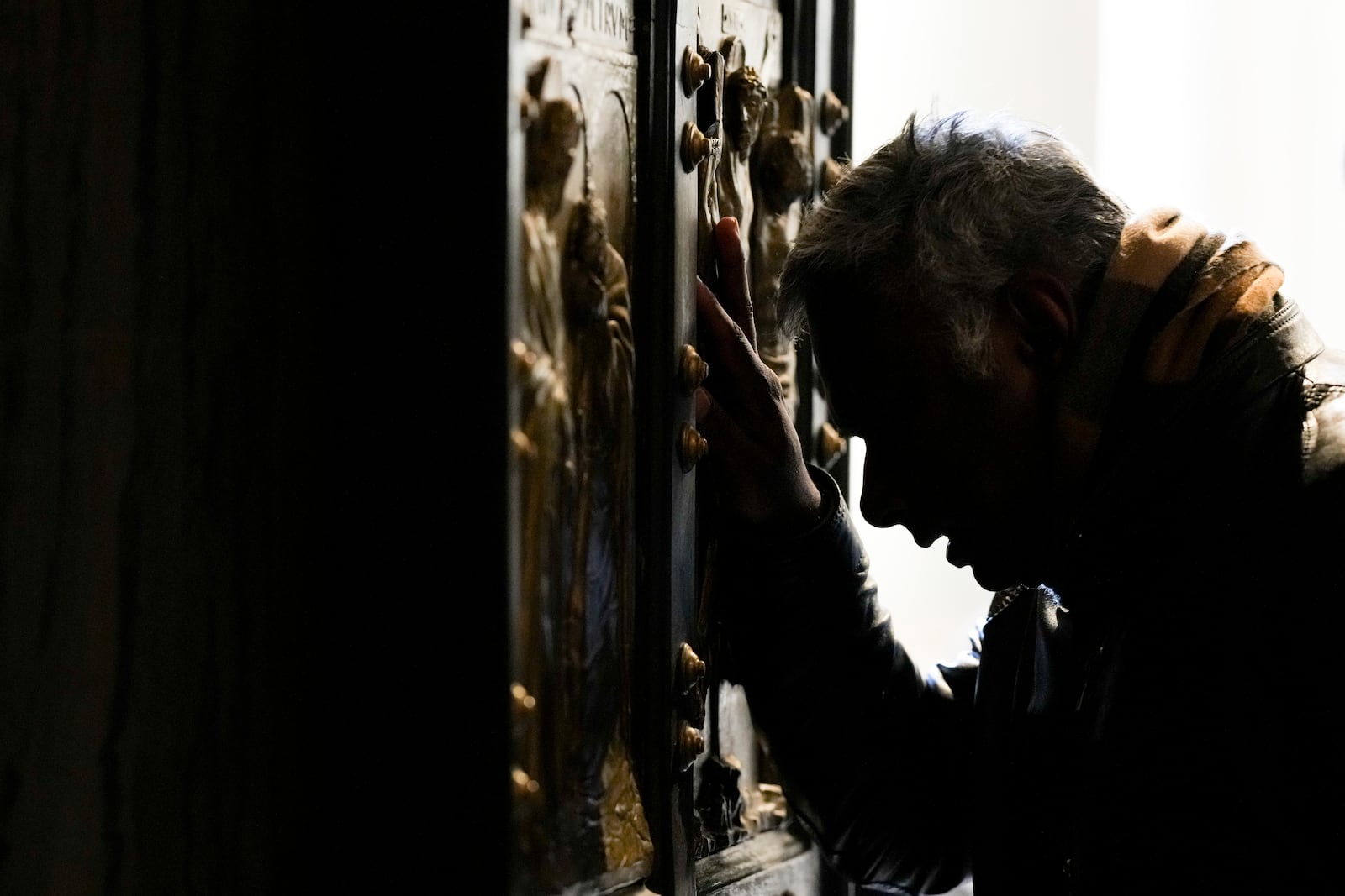 A man stops in prayer as he walks through the Holy Door of St.Peter's Basilica at the Vatican, Wednesday, Dec. 25, 2024, after it was opened by Pope Francis on Christmas Eve marking the start of the Catholic 2025 Jubilee. (AP Photo/Andrew Medichini)