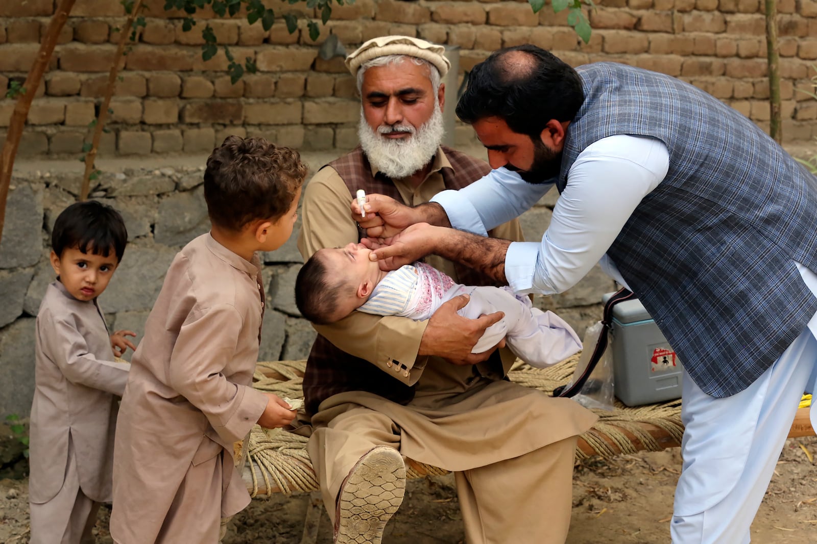 A health worker administers a polio vaccine to a child at a neighborhood of Jalalabad, east of Kabul, Afghanistan, Tuesday, Oct. 29, 2024. (AP Photo/Shafiullah Kakar)