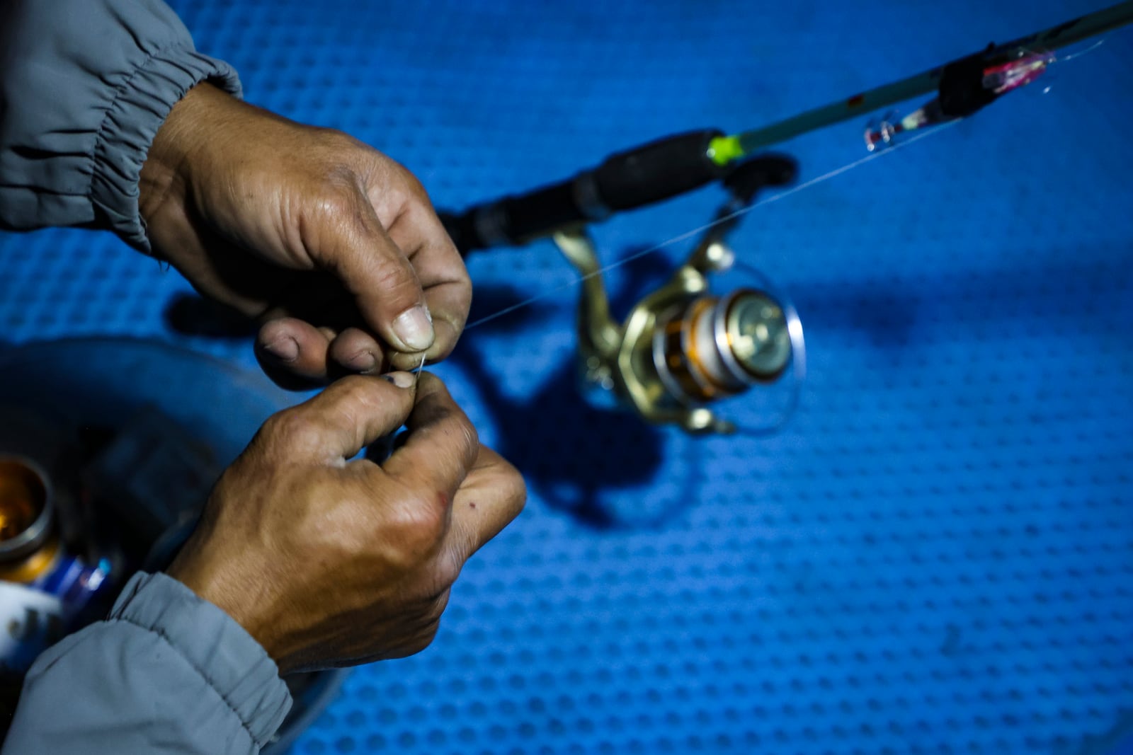 Nguyen Van Ty fixes a line during a squid fishing trip off Hon Tam Island on Feb. 7, 2025, in Nha Trang, Vietnam. (AP Photo/Yannick Peterhans)