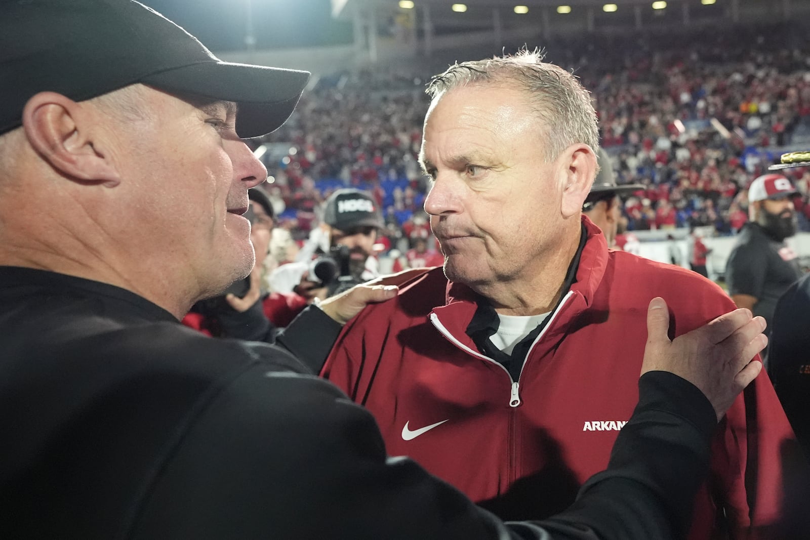 Texas Tech head coach Joey McGuire, left, meets Arkansas head coach Sam Pittman, right, on the field after the Liberty Bowl NCAA college football game Friday, Dec. 27, 2024, in Memphis, Tenn. (AP Photo/George Walker IV)