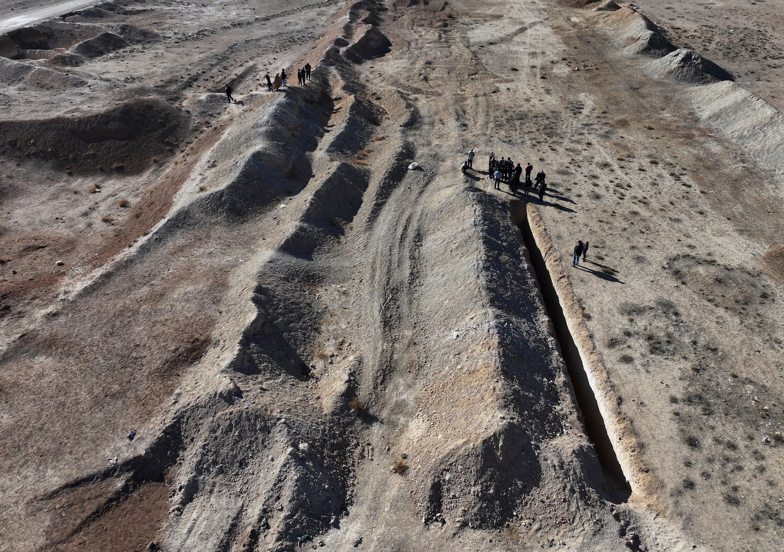 Activists from The U.S.-based Syrian Emergency Task Force and people observe a location identified as a mass grave for detainees killed under rule of Bashar Assad in Najha, south of Damascus, Syria, Tuesday, Dec. 17, 2024. (AP Photo/Hussein Malla)