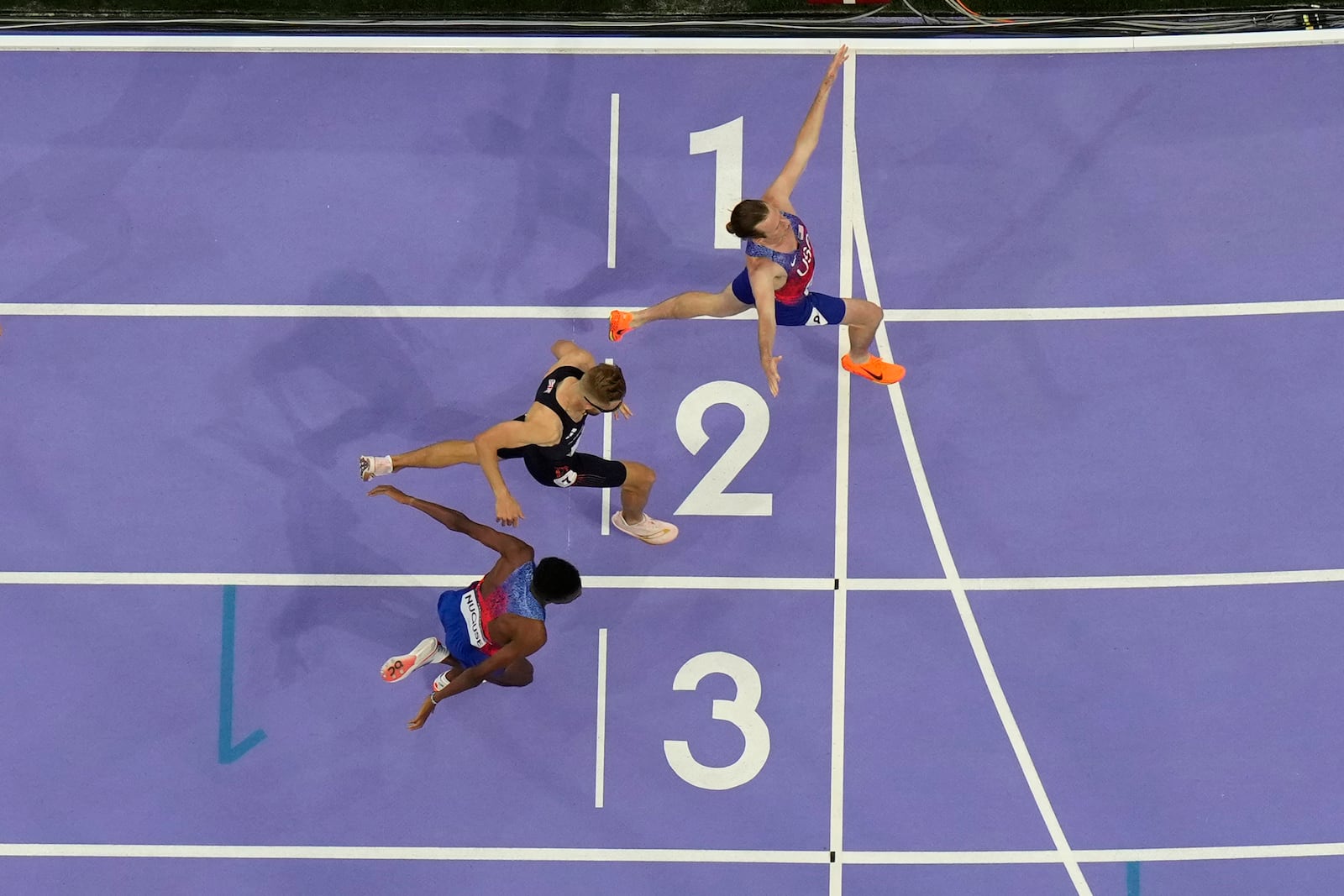 FILE - Cole Hocker, of the United States, top, celebrates after setting a new Olympic record winning the men's 1,500-meter final at the 2024 Summer Olympics, Tuesday, Aug. 6, 2024, in Saint-Denis, France. (AP Photo/David J. Phillip, File)