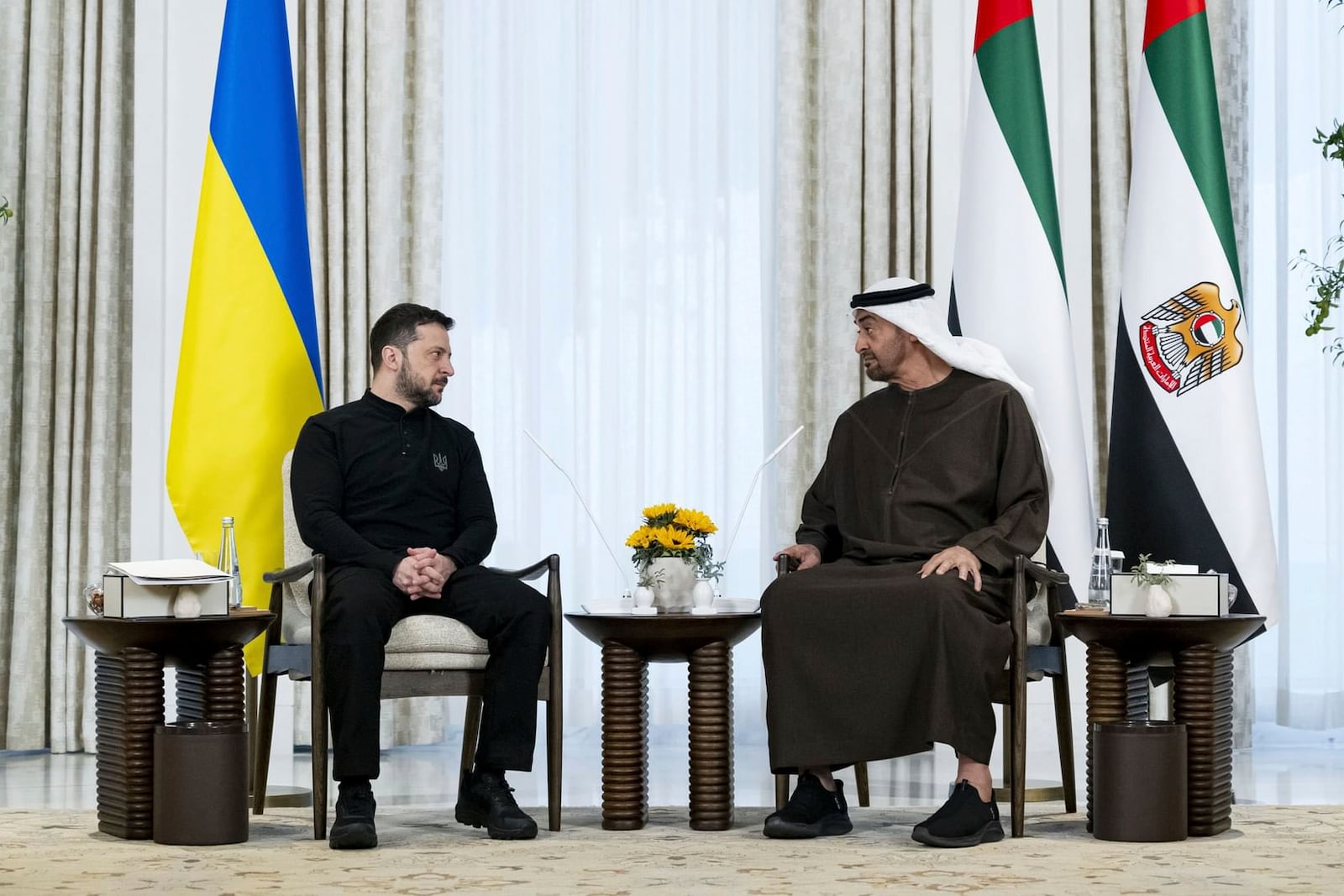 In this photograph, released by the state-run WAM news agency, United Arab Emirates President Sheikh Mohammed bin Zayed Al Nahyan, right, and Ukrainian President Volodymyr Zelenskyy, left, talk during their meeting in Abu Dhabi, United Arab Emirates, Monday, Feb. 17, 2025. (WAM via AP)