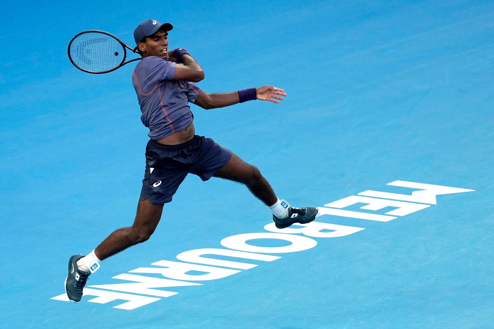 Nishesh Basavareddy of the U.S. plays a forehand return to Novak Djokovic of Serbia during their first round match at the Australian Open tennis championship in Melbourne, Australia, Monday, Jan. 13, 2025. (AP Photo/Asanka Brendon Ratnayake)