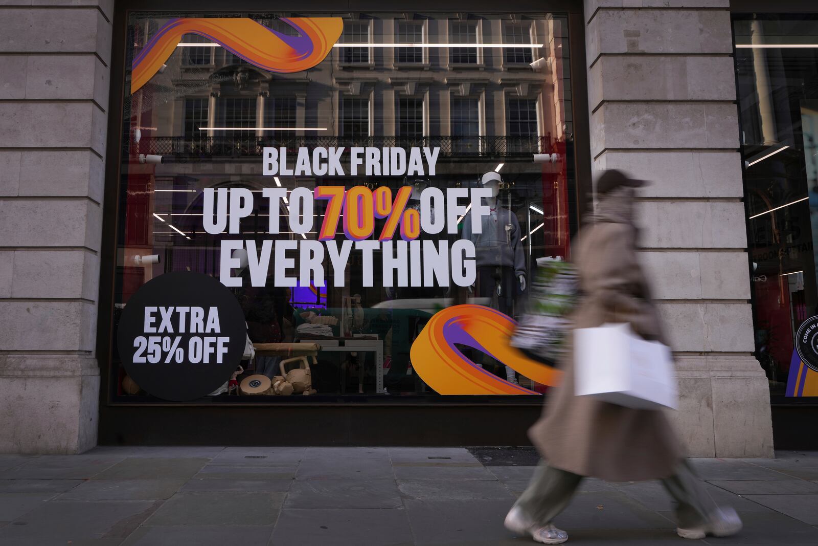 A shopper passes a store advertising a Black Friday Sale on Regent Street in London, Thursday, Nov. 28, 2024. (AP Photo/Kirsty Wigglesworth)