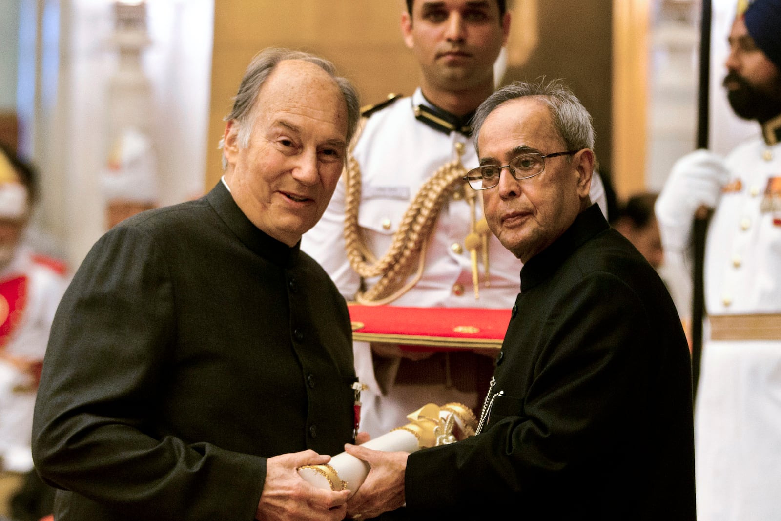 FILE - Indian President Pranab Mukherjee confers the Padma Vibhushan to the Aga Khan, spiritual head of Ismaili Muslims, left, during a civil investiture ceremony at the presidential palace in New Delhi, India, Wednesday, April 8, 2015. The Padma Vibhushan is the second highest civilian award in India. (AP Photo/Manish Swarup, File)