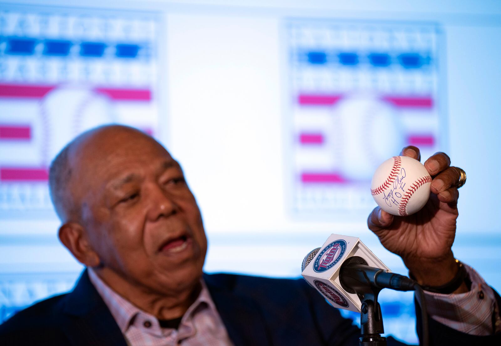 Former Minnesota Twins player Tony Oliva holds up a baseball after signing it with an added "HOF" at a news conference where he talked about his selection to the baseball Hall of Fame, Monday, Dec. 6, 2021, in Minneapolis. The Twins held a joint news conference with new baseball Hall of Fame inductees Oliva and Jim Kaat on Monday. (Jeff Wheeler/Star Tribune via AP)