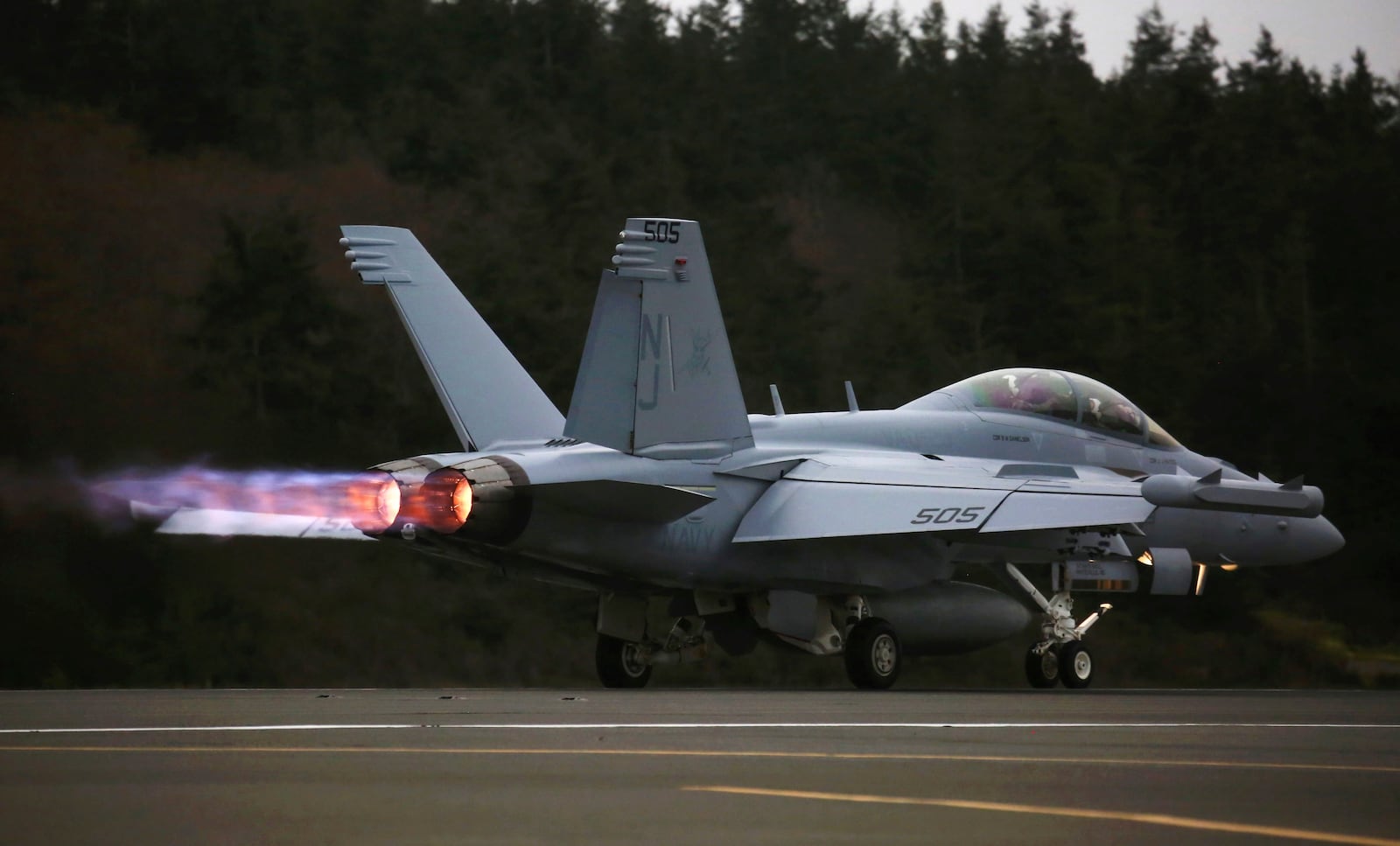 An EA-18G Growler engine's thrust with afterburner propels its takeoff with a loud roar from Naval Air Station Whidbey Island during an exercise, March 10, 2016. (Ken Lambert/The Seattle Times via AP)