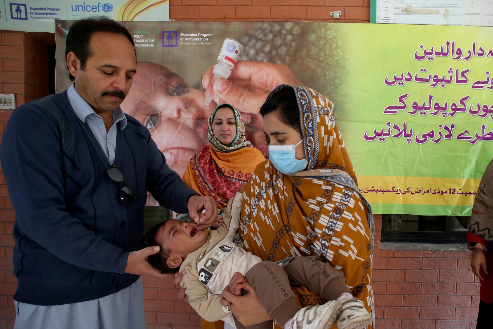 A health worker administers a polio vaccine to a child at a health center in Peshawar, Pakistan, Monday, Dec. 16, 2024. (AP Photo/Muhammad Sajjad)