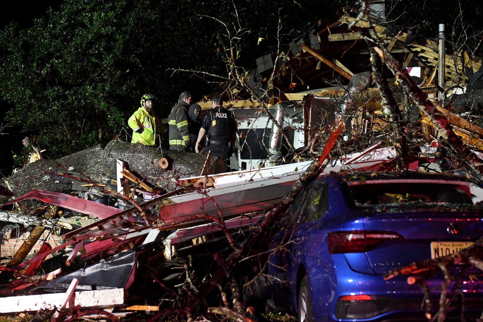 First responders work to free a victim after a tree fell on a house in Natchez, Miss., Saturday, Dec. 28, 2024. (Thomas Graning/The Natchez Democrat via AP)