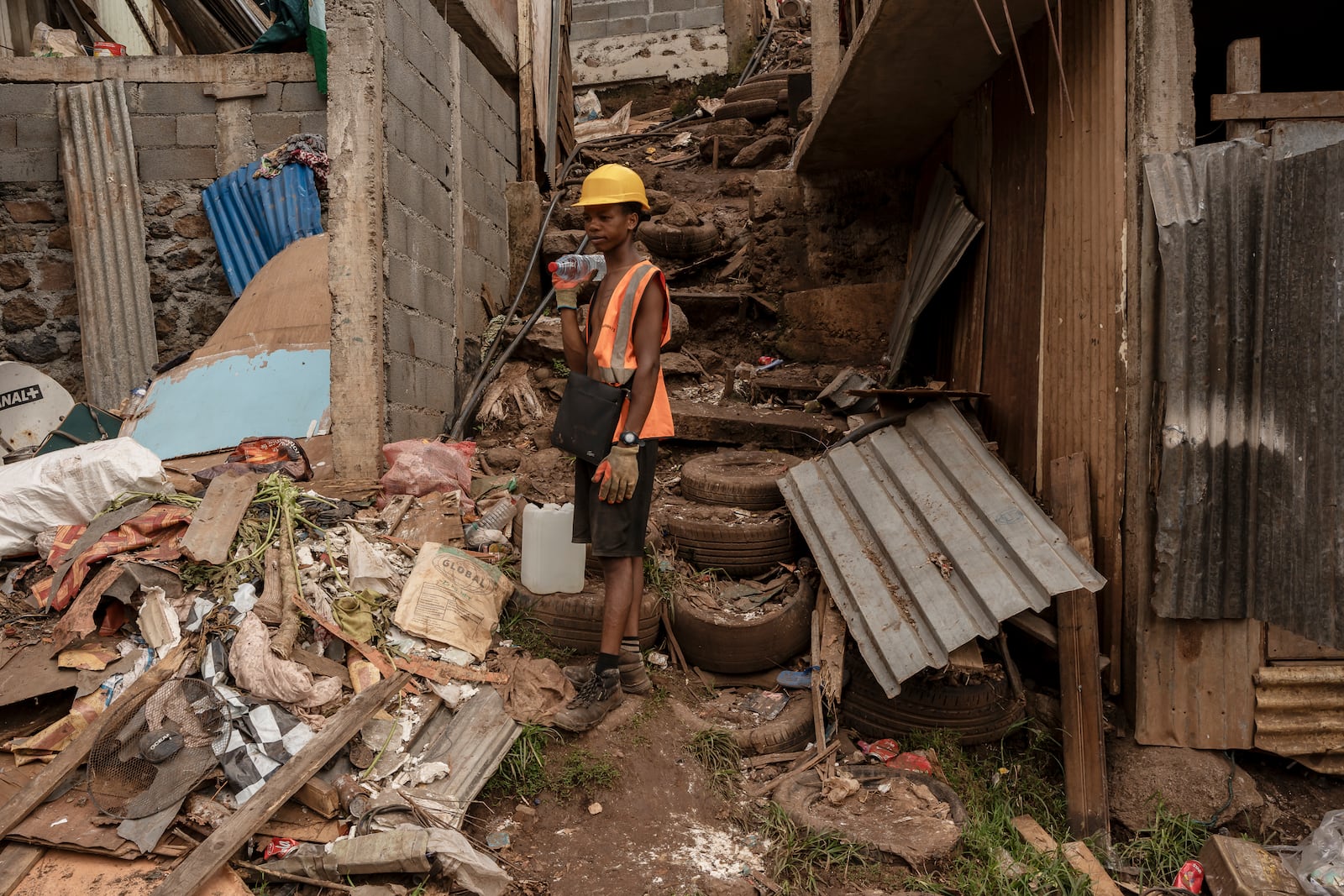 A boy stands amidst debris in the Kaweni slum on the outskirts of Mamoudzou in the French Indian Ocean island of Mayotte, Thursday, Dec. 19, 2024, after Cyclone Chido. (AP Photo/Adrienne Surprenant)