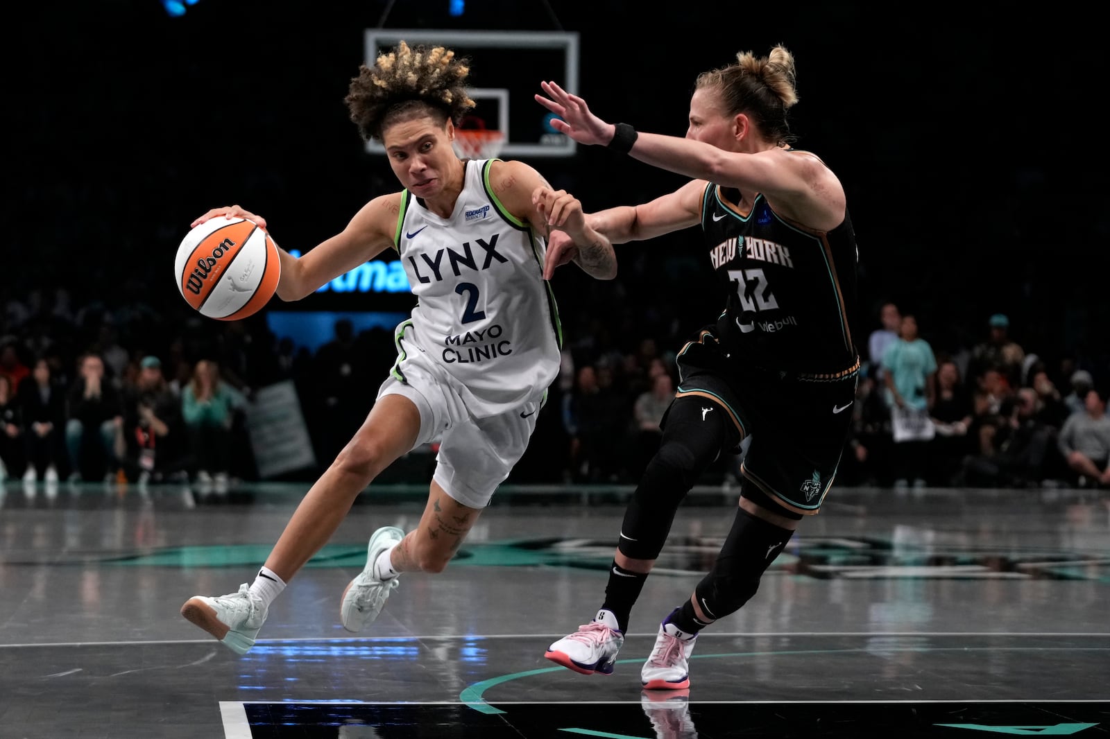 Minnesota Lynx's Natisha Hiedeman, left, dribbles against New York Liberty's Courtney Vandersloot, right, during the second half in Game 1 of a WNBA basketball final playoff series, Thursday, Oct. 10, 2024, in New York. (AP Photo/Pamela Smith)