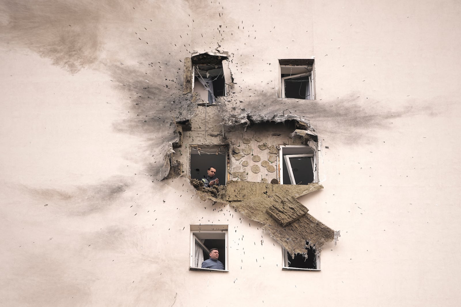 Investigators look at the damage of an apartment building where the downed Ukrainian drone fell in Sapronovo village outside Moscow, Russia, on Tuesday, March 11, 2025. (AP Photo)