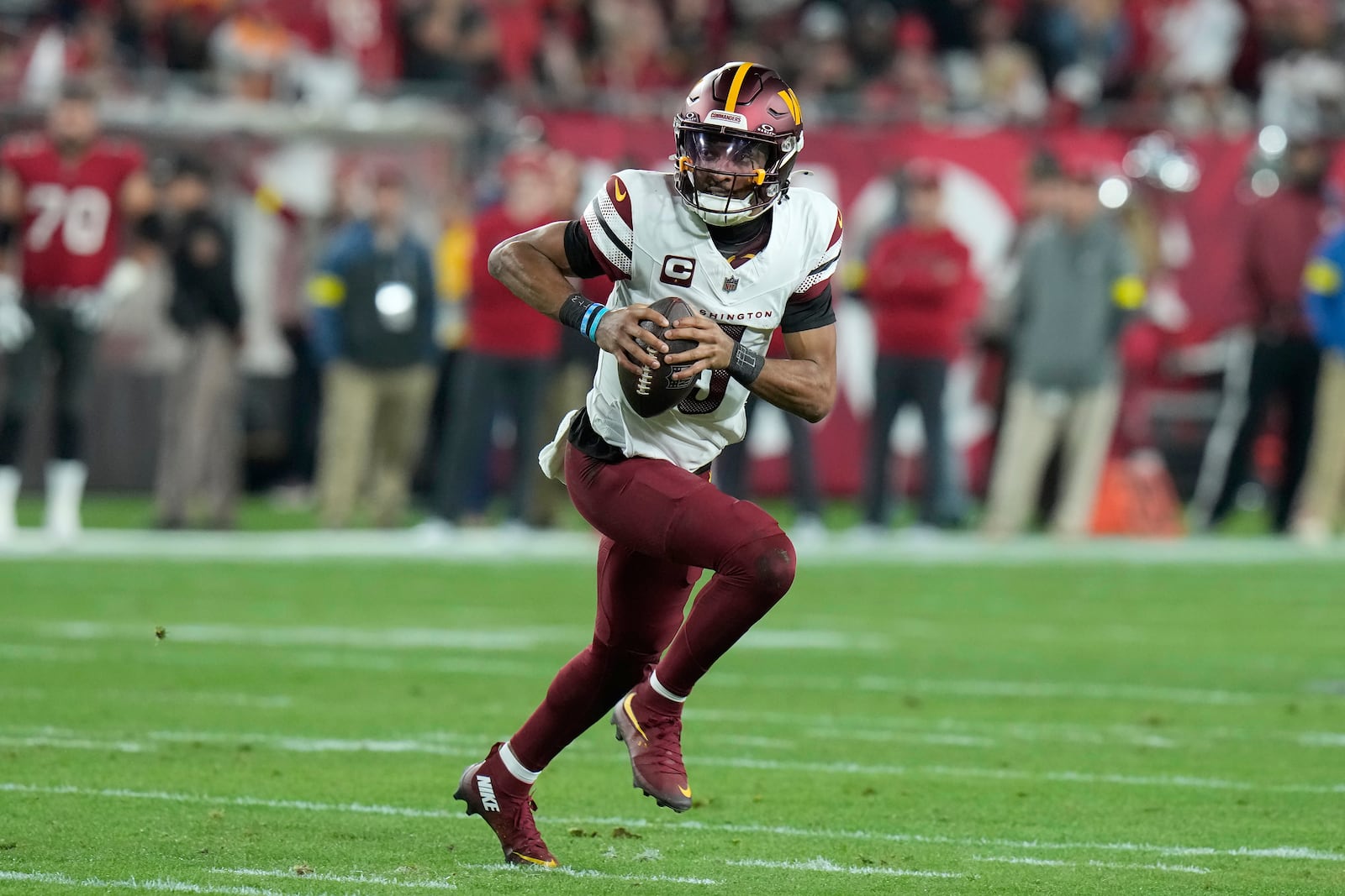 Washington Commanders quarterback Jayden Daniels (5) scrambles out of the pocket against the Tampa Bay Buccaneers during the first half of an NFL wild-card playoff football game in Tampa, Fla., Sunday, Jan. 12, 2025. (AP Photo/Chris O'Meara)