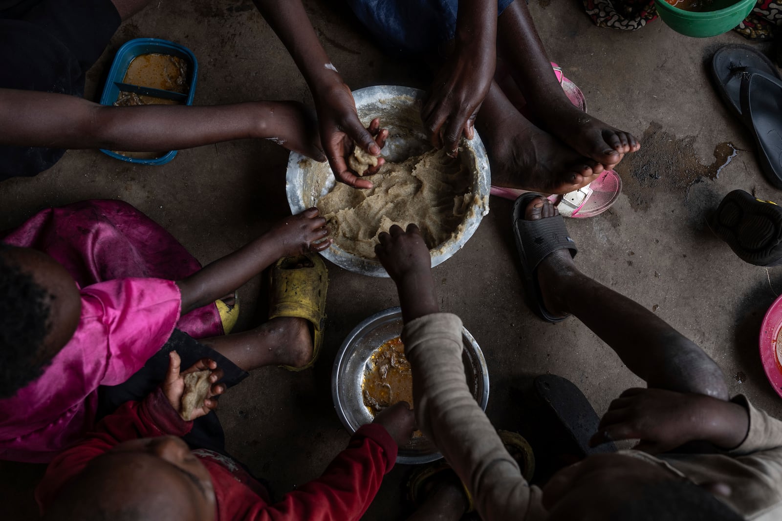 Zawadi Sifa who has been fleeing fighting from camp to camp, shares food with her seven children in Goma, Democratic Republic of the Congo, Thursday, Feb. 5, 2025.(AP Photo/Moses Sawasawa)