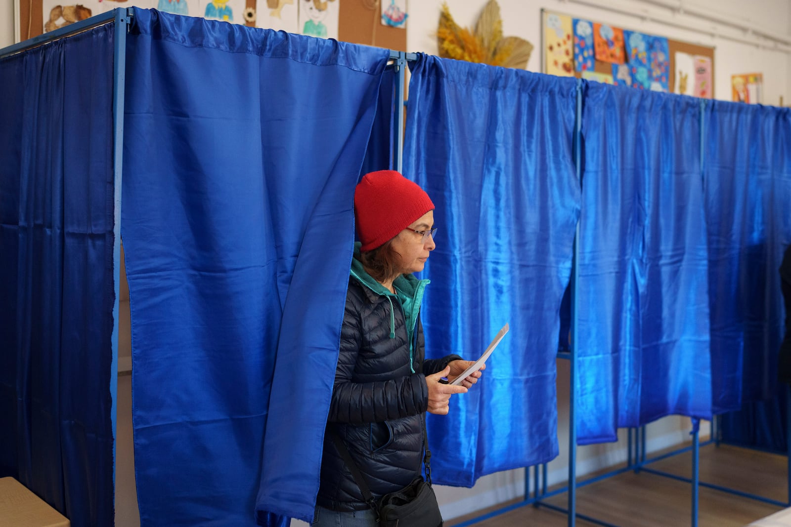 A woman prepares to cast her vote in the country's presidential elections, in Bucharest, Romania, Sunday, Nov. 24, 2024. (AP Photo/Vadim Ghirda)