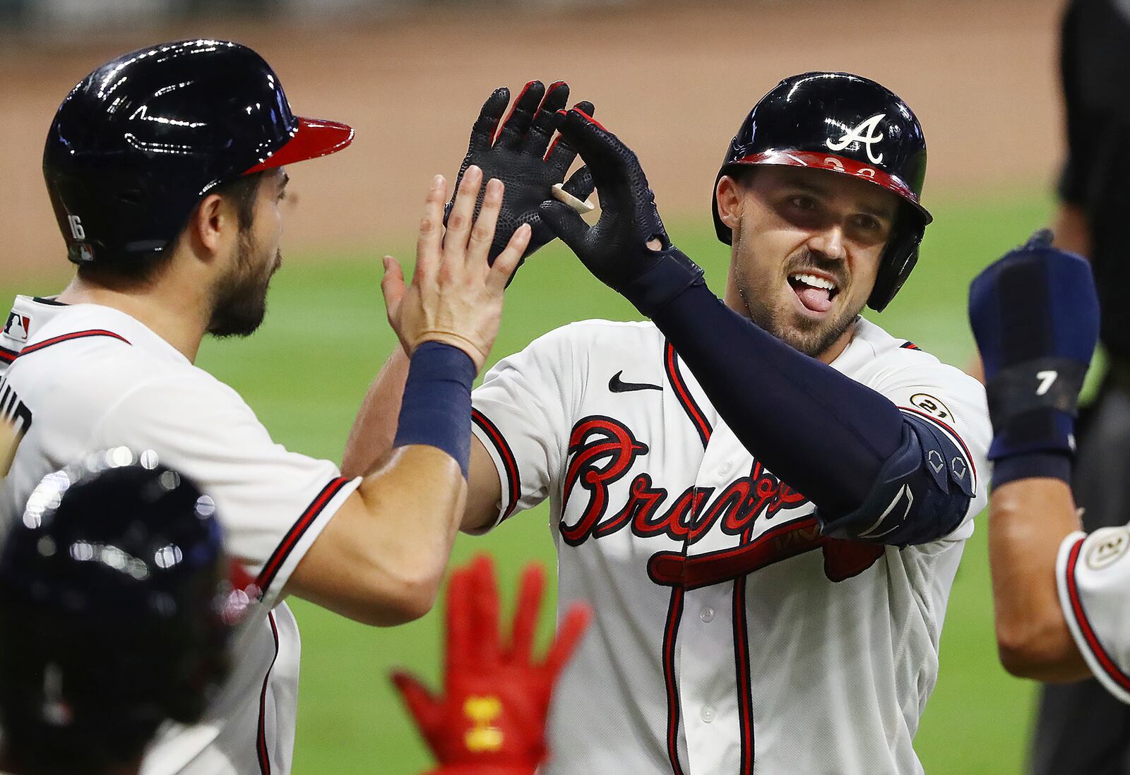 Atlanta Braves' Adam Duval, right, is greeted at home by Travis d'Arnaud, left, after hitting a grand slam, his third homer of the night, for a 29-9 lead over the Miami Marlins during the seventh inning of a baseball game Wednesday, Sept. 9, 2020, in Atlanta. (Curtis Compton/Atlanta Journal-Constitution via AP)