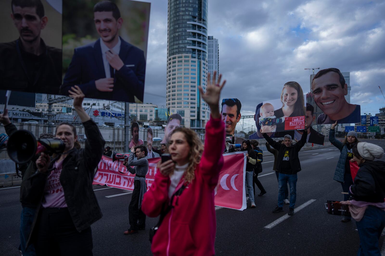 Relatives and supporters of Israelis held hostage in the Gaza Strip, hold photos depicting their faces during a protest demanding their release from Hamas captivity, in Tel Aviv, Israel, Thursday, Feb. 13, 2025. (AP Photo/Oded Balilty)