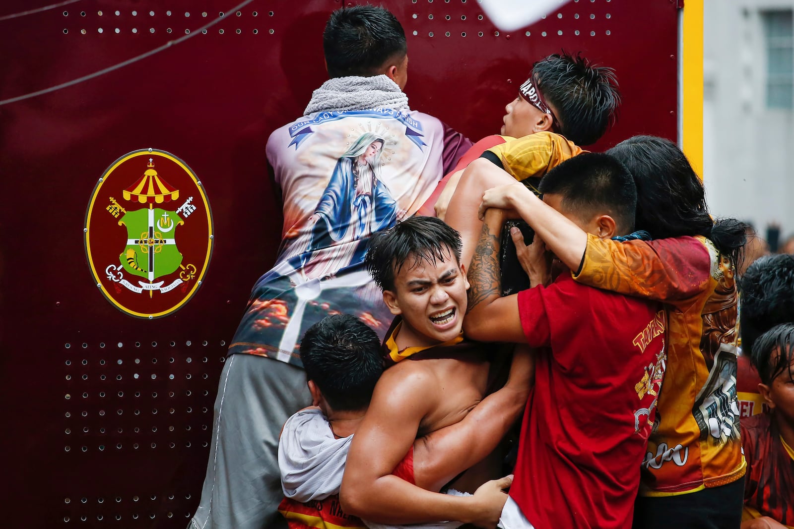 Devotees try to touch the image of Jesus Nazareno inside a glass-covered carriage during its annual procession in Manila, Philippines Thursday, Jan. 9, 2025. (AP Photo/Basilio Sepe)