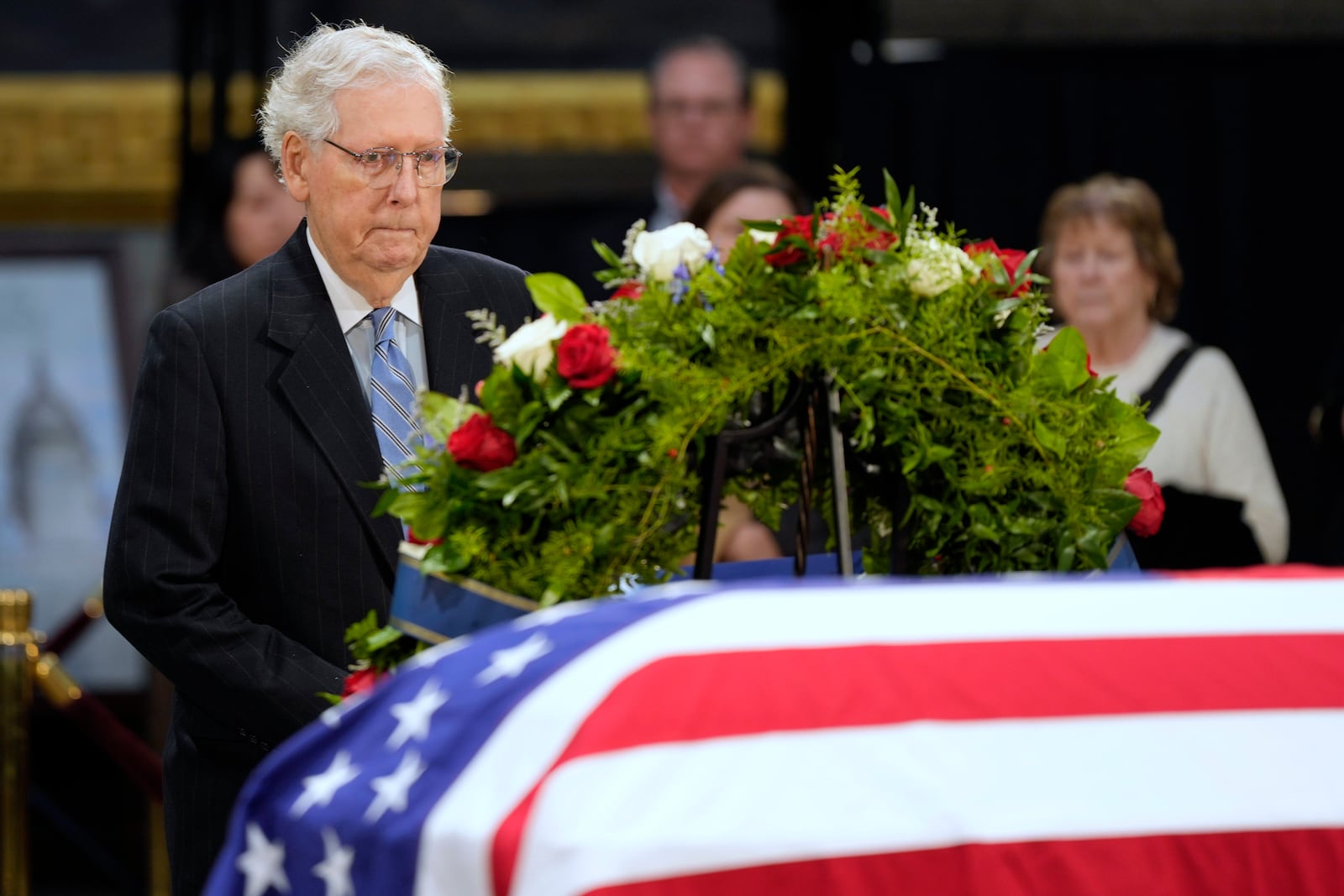 Sen. Mitch McConnell, R-Ky., pauses the flag-draped casket of former President Jimmy Carter as he lies in state at the U.S. Capitol, Wednesday, Jan. 8, 2025, in Washington. Carter died Dec. 29 at the age of 100. (AP Photo/Steve Helber)