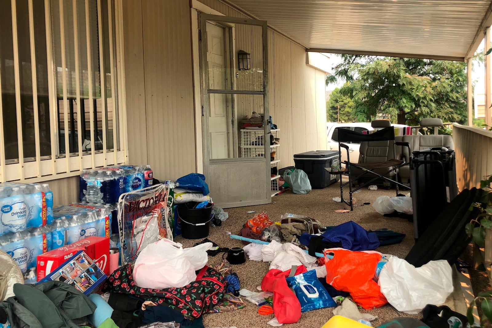 FILE - Cases of bottled water are seen with other items left on the porch of a house where killings occurred related to a Marijuana growing operation in Aguanga ,Calif., Tuesday, Sept. 8, 2020. (AP Photo/Elliot Spagat, File)