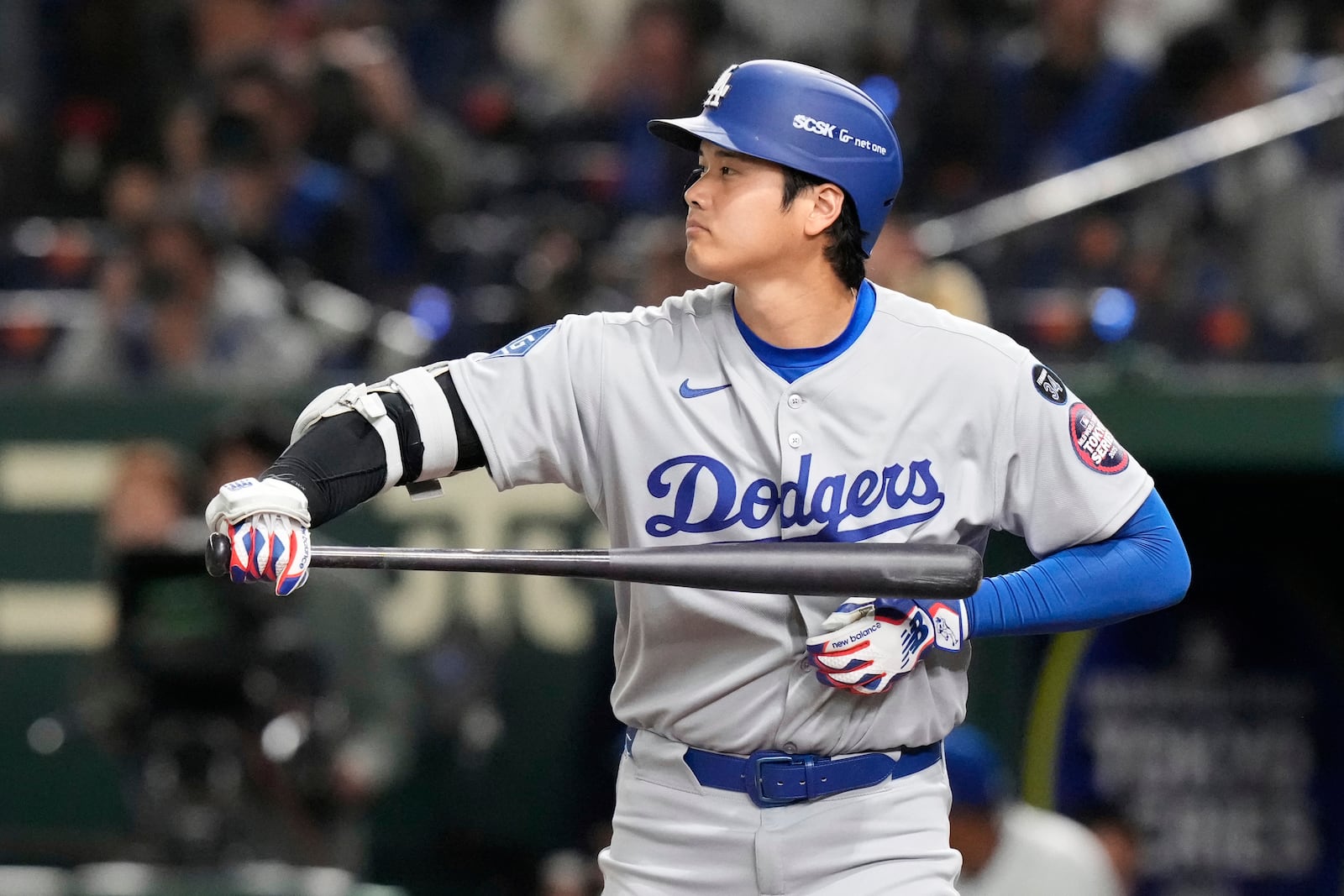 Los Angeles Dodgers' Shohei Ohtani wipes his bat during an at-bat in the sixth inning of an MLB Japan Series baseball game against the Chicago Cubs in Tokyo, Japan, Tuesday, March 18, 2025. (AP Photo/Eugene Hoshiko)