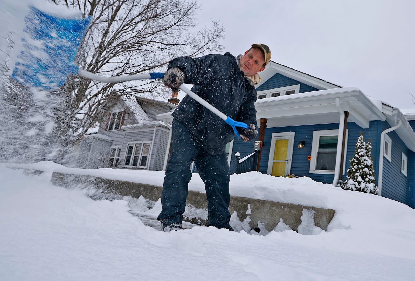 James Ryhal, from Ryhal Landscaping, shovels a clients sidewalk along East Cecil Street in Springfield Tuesday, Jan. 7, 2025. BILL LACKEY/STAFF