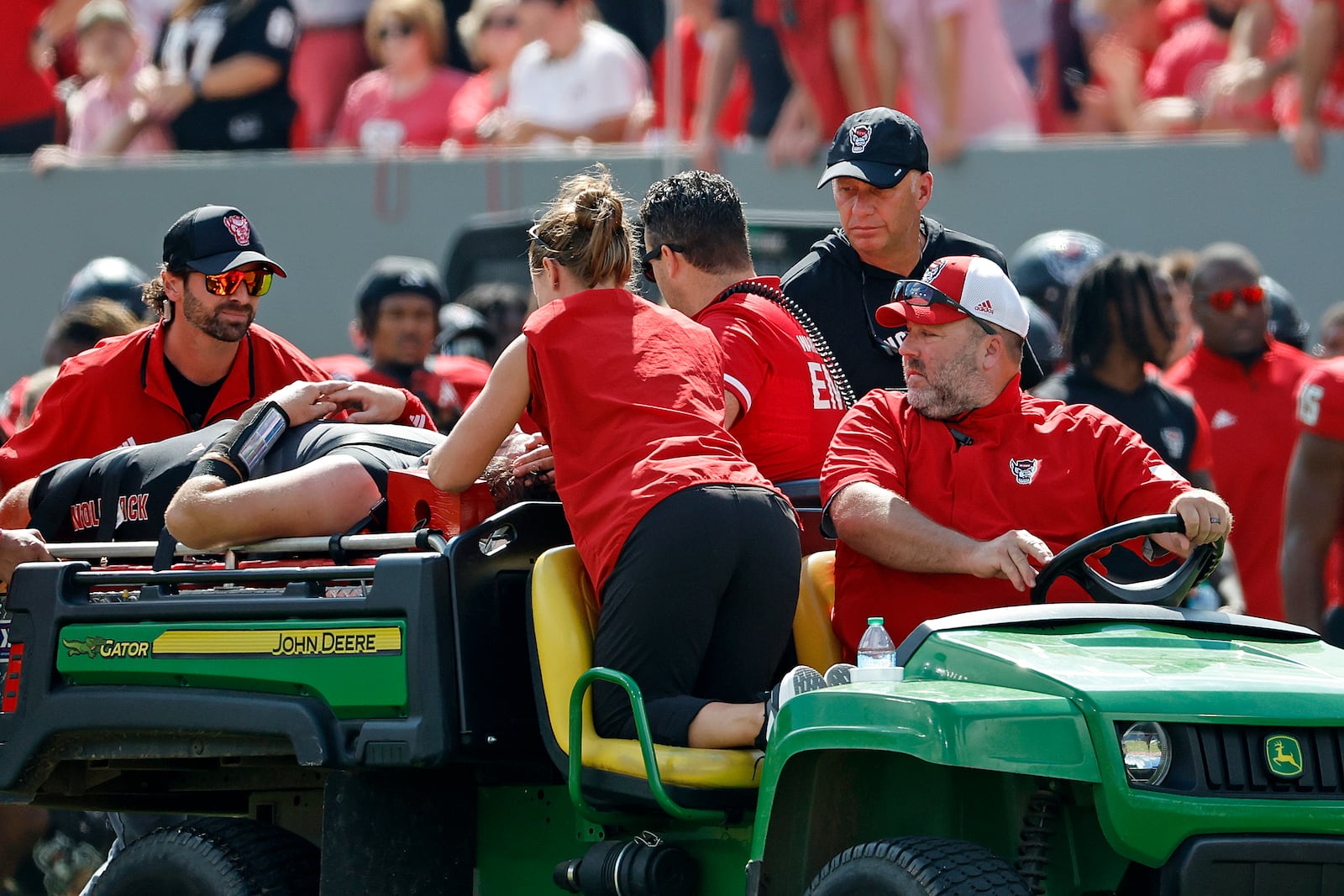 North Carolina State head coach Dave Doeren, rear right, checks on quarterback Grayson McCall (2) as he is carted from the field following an injury during the first half of an NCAA college football game in Raleigh, N.C., Saturday, Oct. 5, 2024. (AP Photo/Karl B DeBlaker)