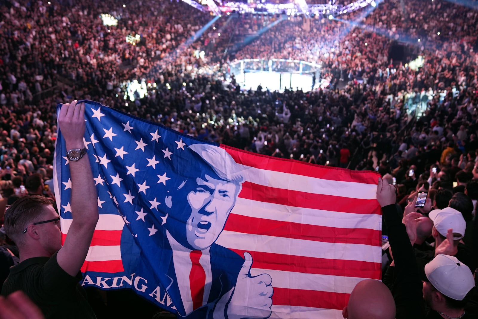 People hold a flag as President-elect Donald Trump arrives at UFC 309 at Madison Square Garden, Saturday, Nov. 16, 2024, in New York. (AP Photo/Evan Vucci)