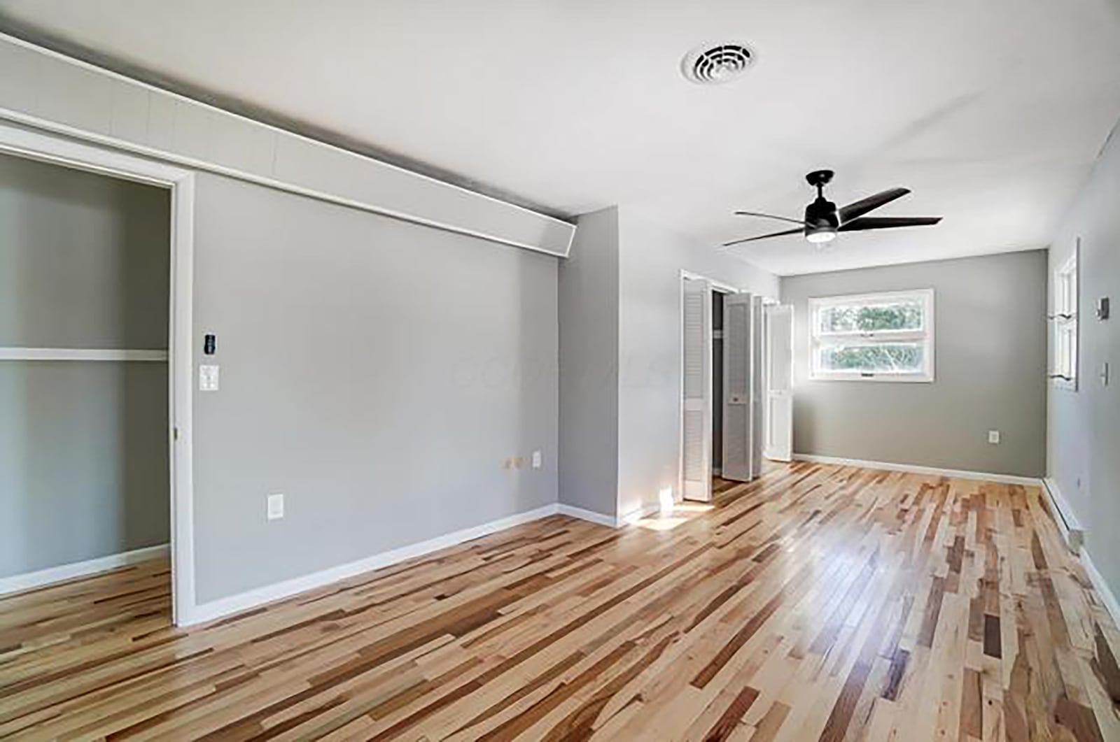 The primary bedroom suite has new hardwood flooring, a ceiling fan and an ensuite bathroom with tile flooring.