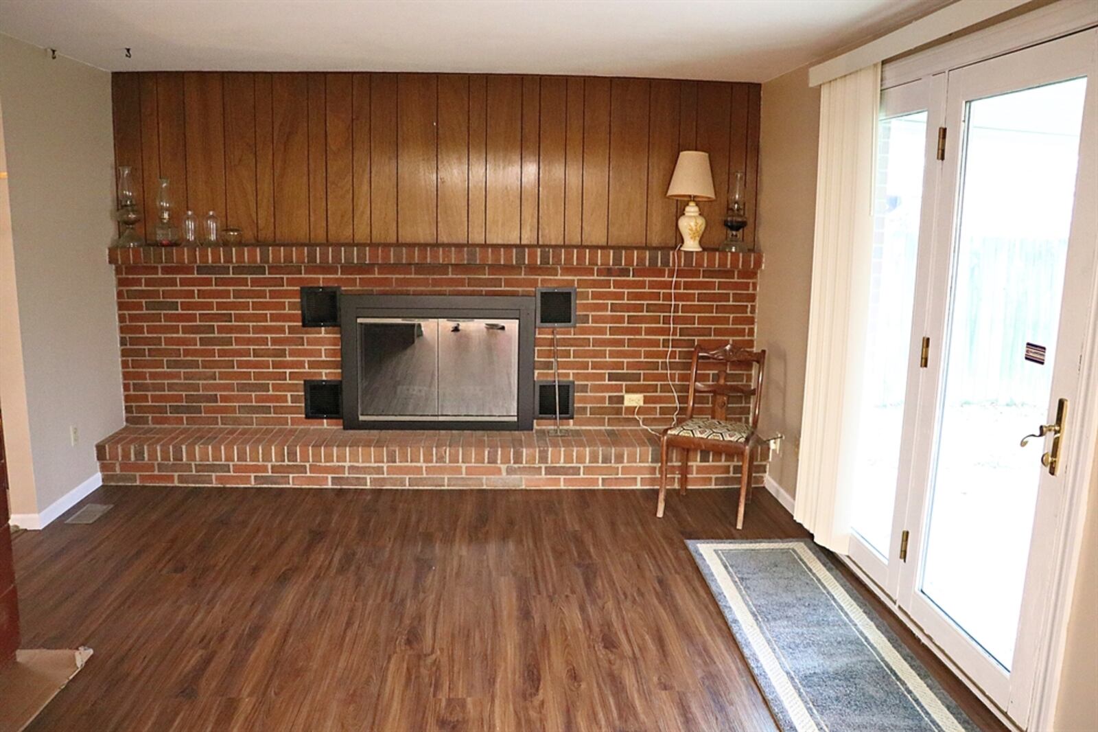 A brick wood-burning fireplace fills one wall of the family room and has a raised brick hearth and a wood-beam mantel. CONTRIBUTED BY KATHY TYLER