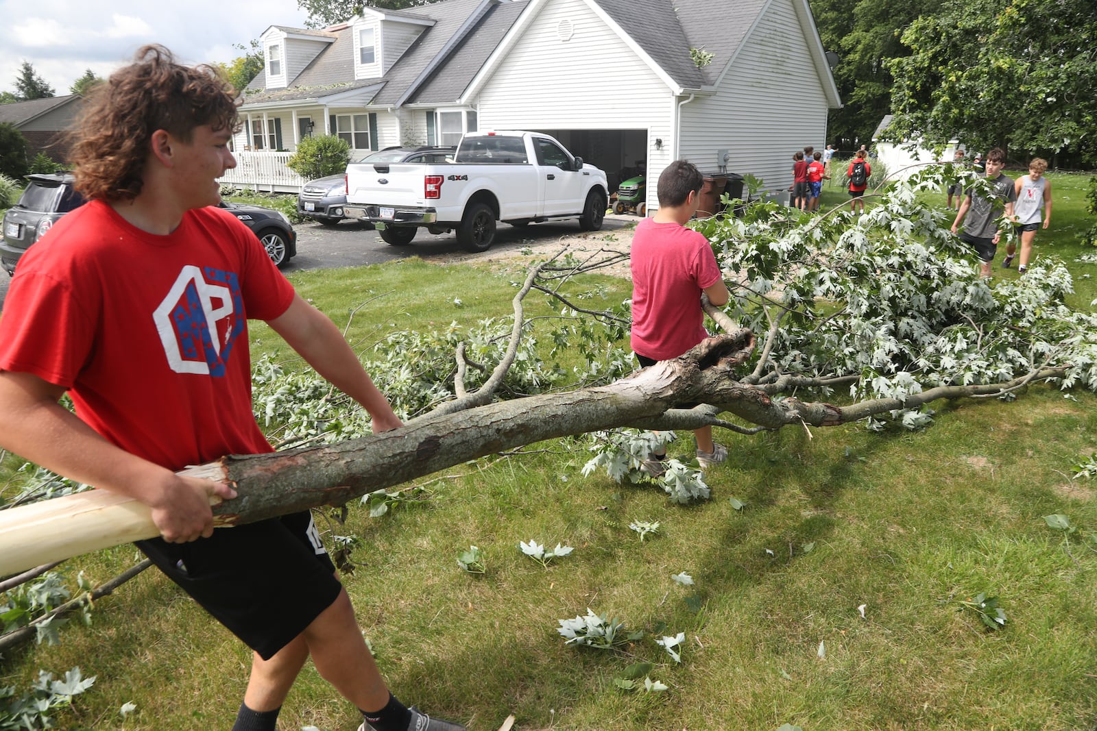 Members of the Northwestern High School football team volunteered to help clean up Thursday, june 9, 2022, after Wednesday’s storm caused extensive damage in German Twp. An EF1 tornado touched down north of Springfield. BILL LACKEY/STAFF