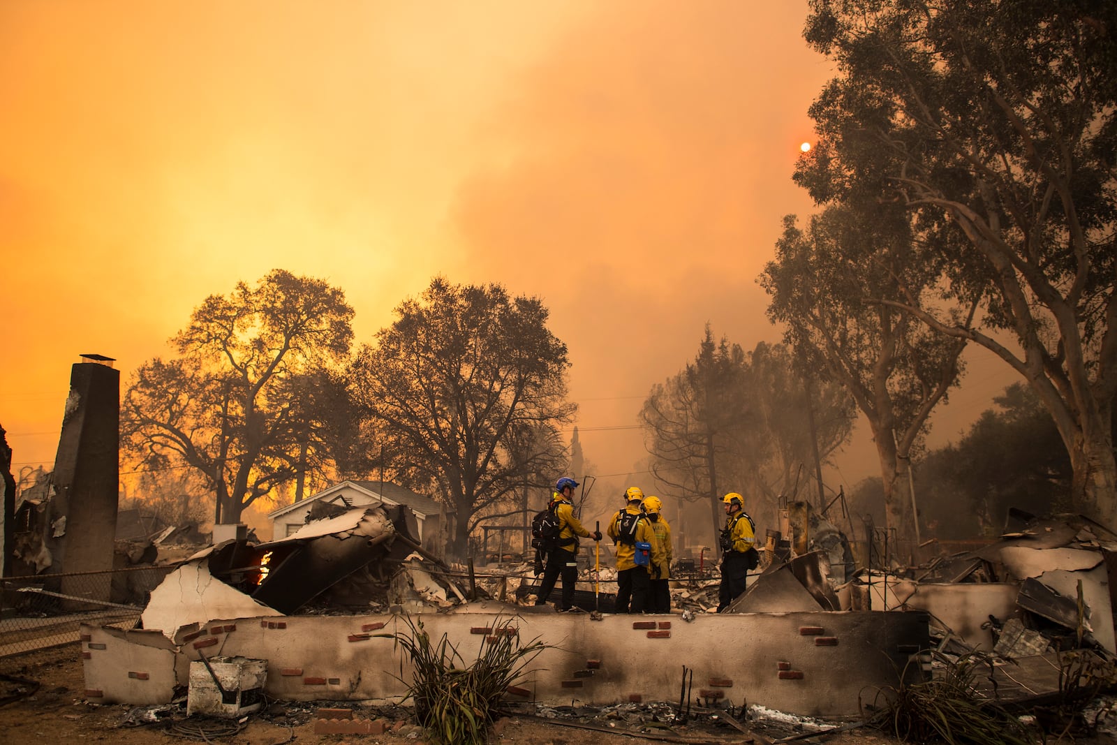 Firefighters work inside a burned structure while battling the Eaton Fire, Wednesday, Jan. 8, 2025, in Altadena, Calif. (AP Photo/Nic Coury)