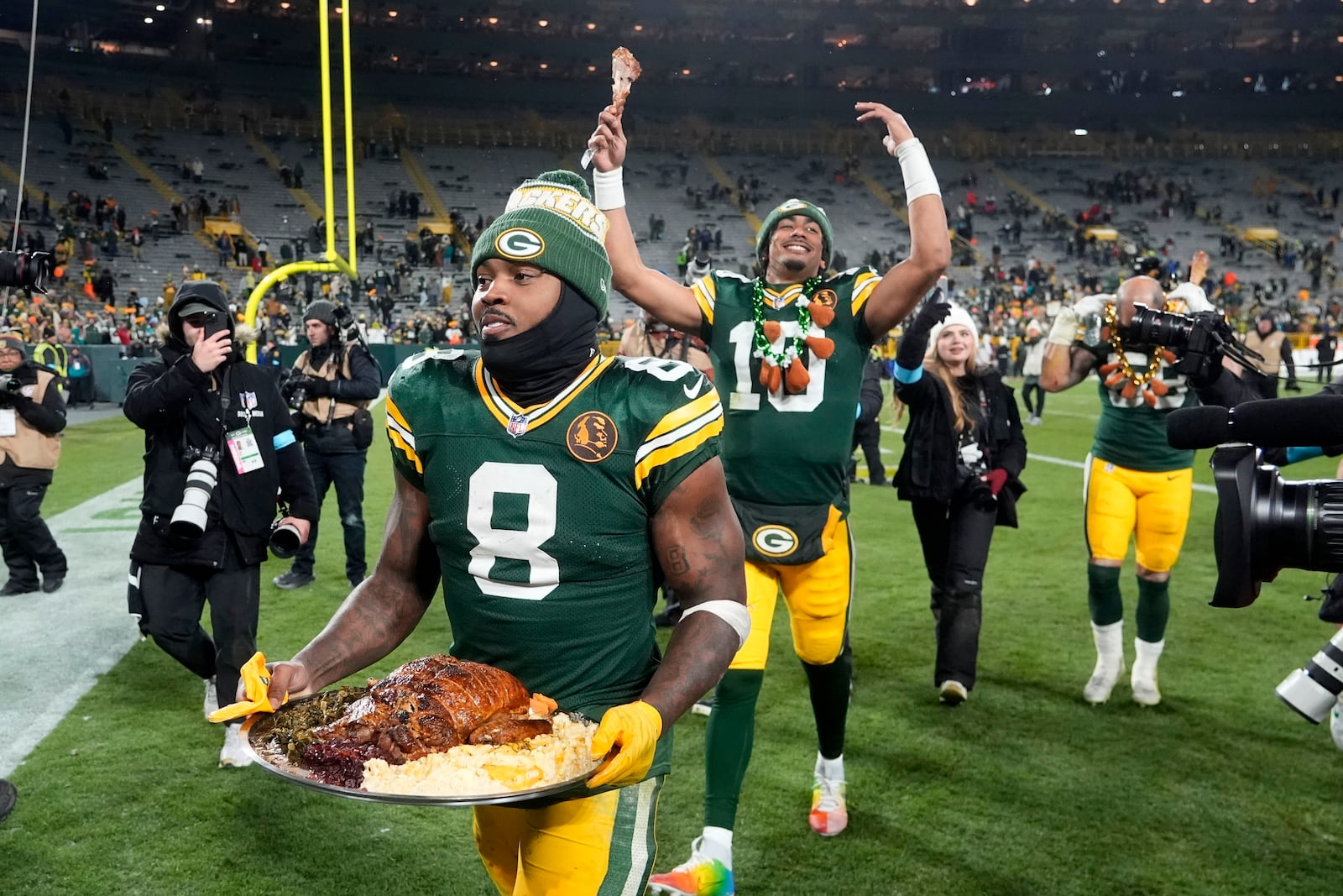 Green Bay Packers running back Josh Jacobs (8) and quarterback Jordan Love (10) walk off the field after an NFL football game against the Miami Dolphins Thursday, Nov. 28, 2024, in Green Bay, Wis. (AP Photo/Morry Gash)