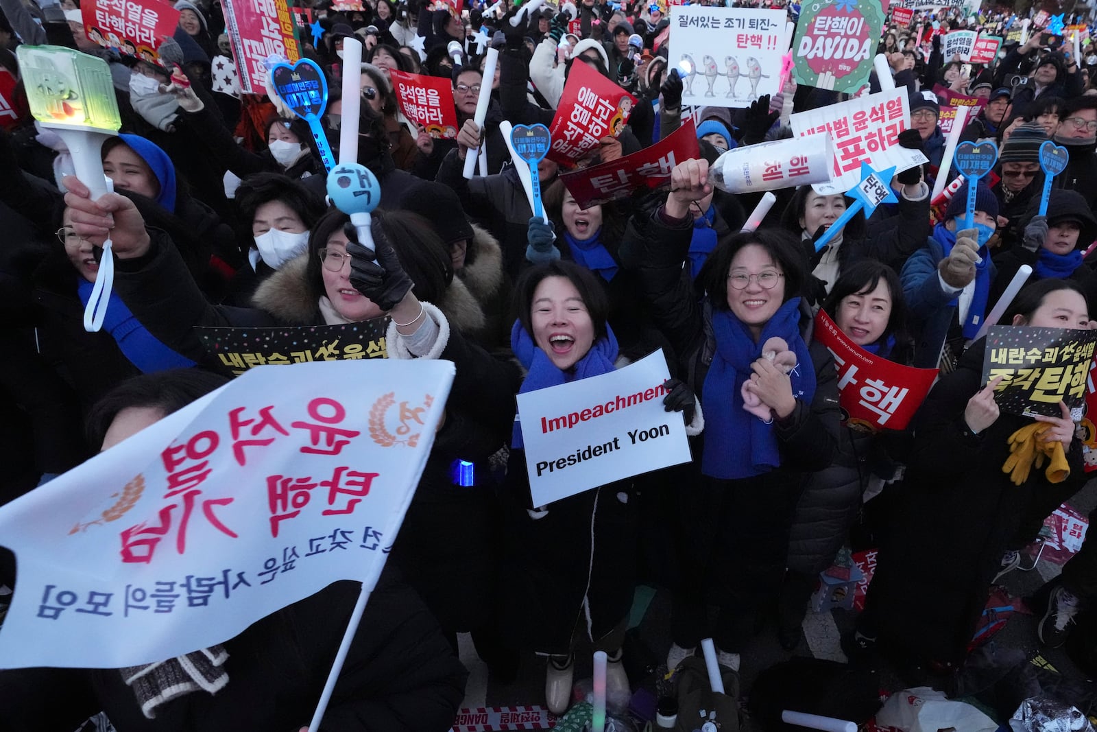 Participants react after hearing the news that South Korea's parliament voted to impeach President Yoon Suk Yeol outside the National Assembly in Seoul, South Korea, Saturday, Dec. 14, 2024. (AP Photo/Lee Jin-man)