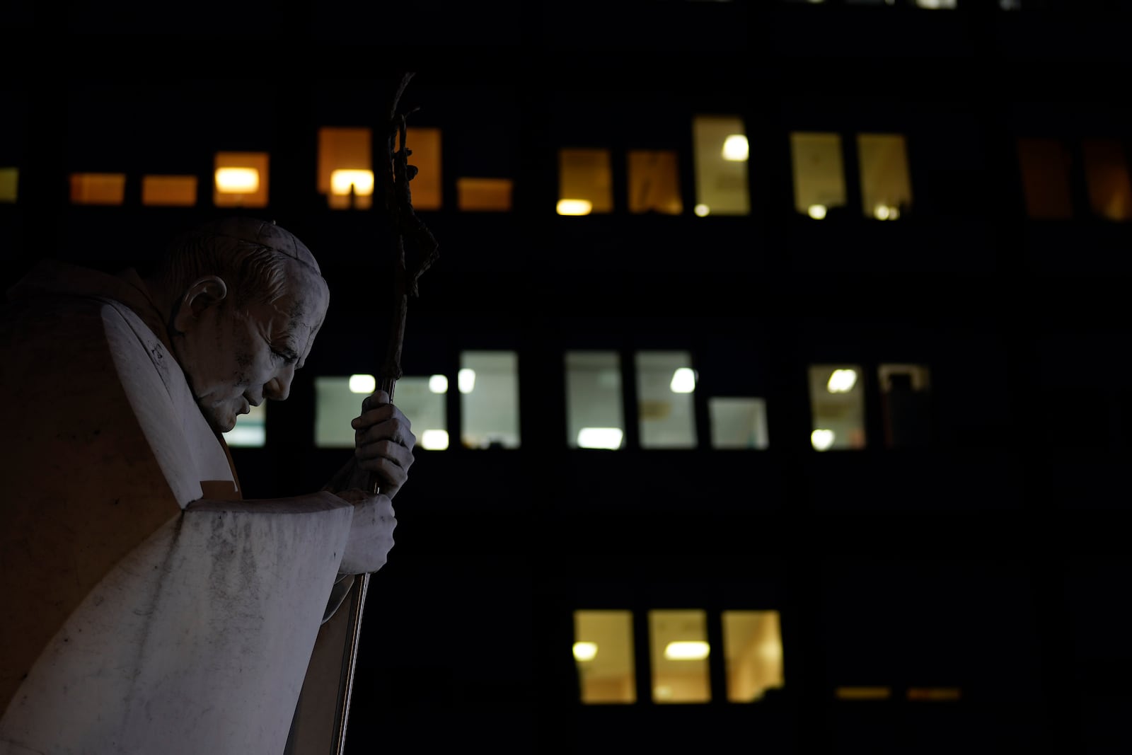 A marble statue of late Pope John Paul II is backdropped by the Agostino Gemelli Polyclinic in Rome, Monday, Feb. 17, 2025, where Pope Francis was hospitalized Friday, Feb. 14, after a weeklong bout of bronchitis worsened and is receiving drug therapy for a respiratory tract infection. (AP Photo/Gregorio Borgia)