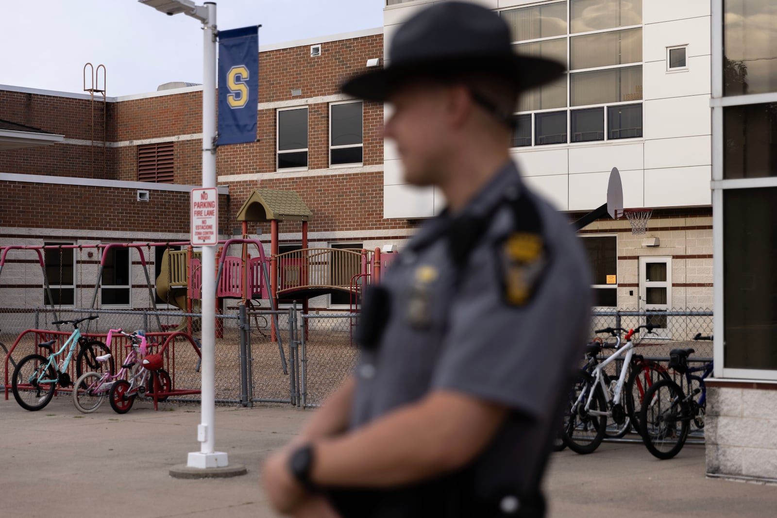 
                        An Ohio state trooper stands guard at Snowhill Elementary School in Springfield, Ohio, on Tuesday morning, Sept. 17, 2024. Gov. Mike DeWine of Ohio announced Monday that he was deploying state troopers to the beleaguered city of Springfield to reassure the community that schools are safe despite a wave of bomb threats. (Maddie McGarvey/The New York Times)
                      