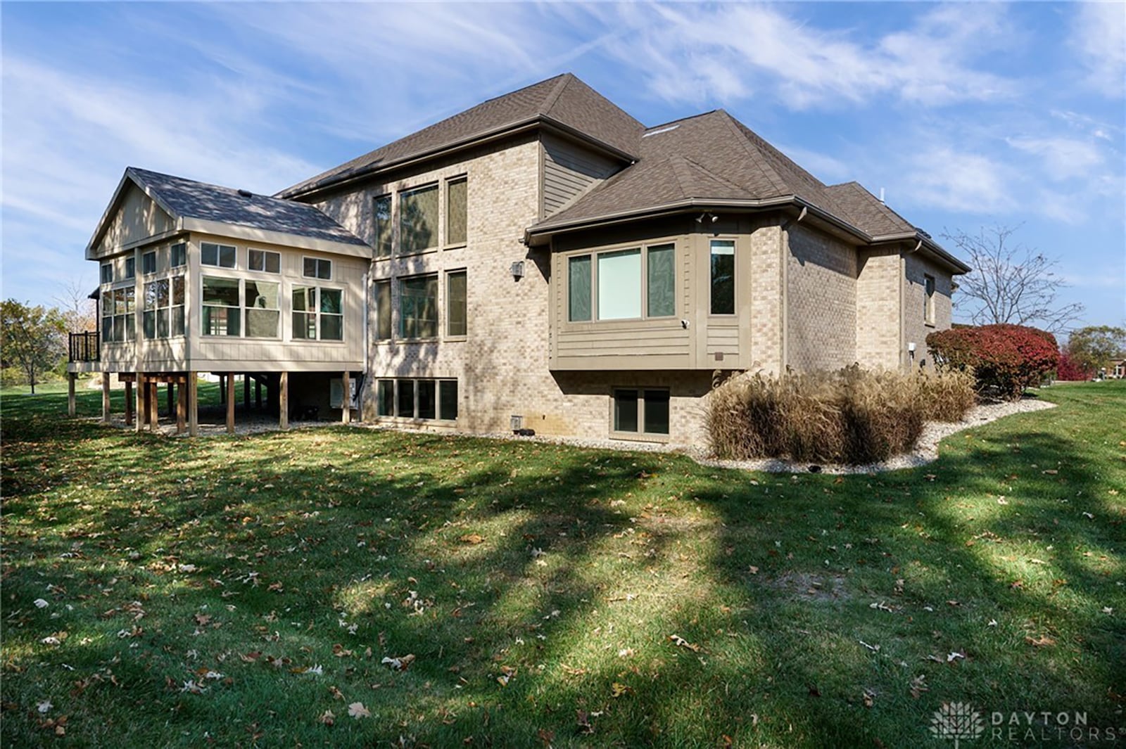 The rear of the home has a covered deck and overlooks the wooded back yard.