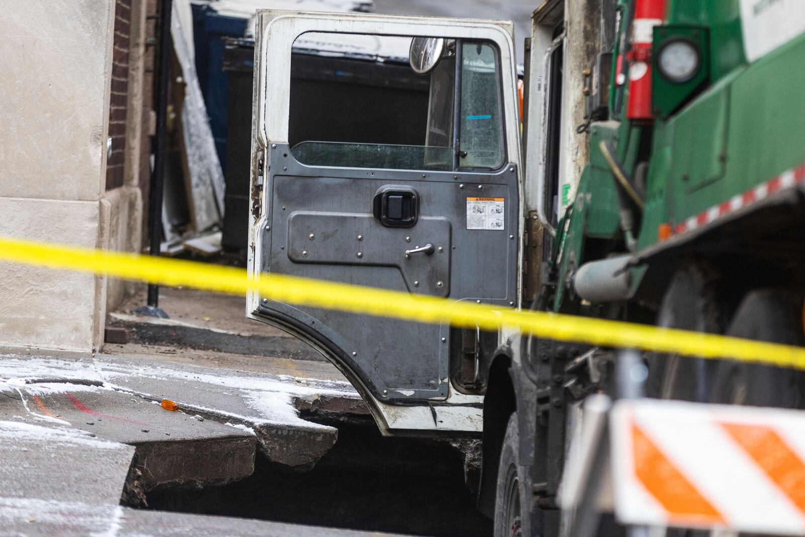 A garbage truck is stuck in a sinkhole in downtown Omaha, Neb., Thursday, Jan. 2, 2025. (Chris Machian/Omaha World-Herald via AP)