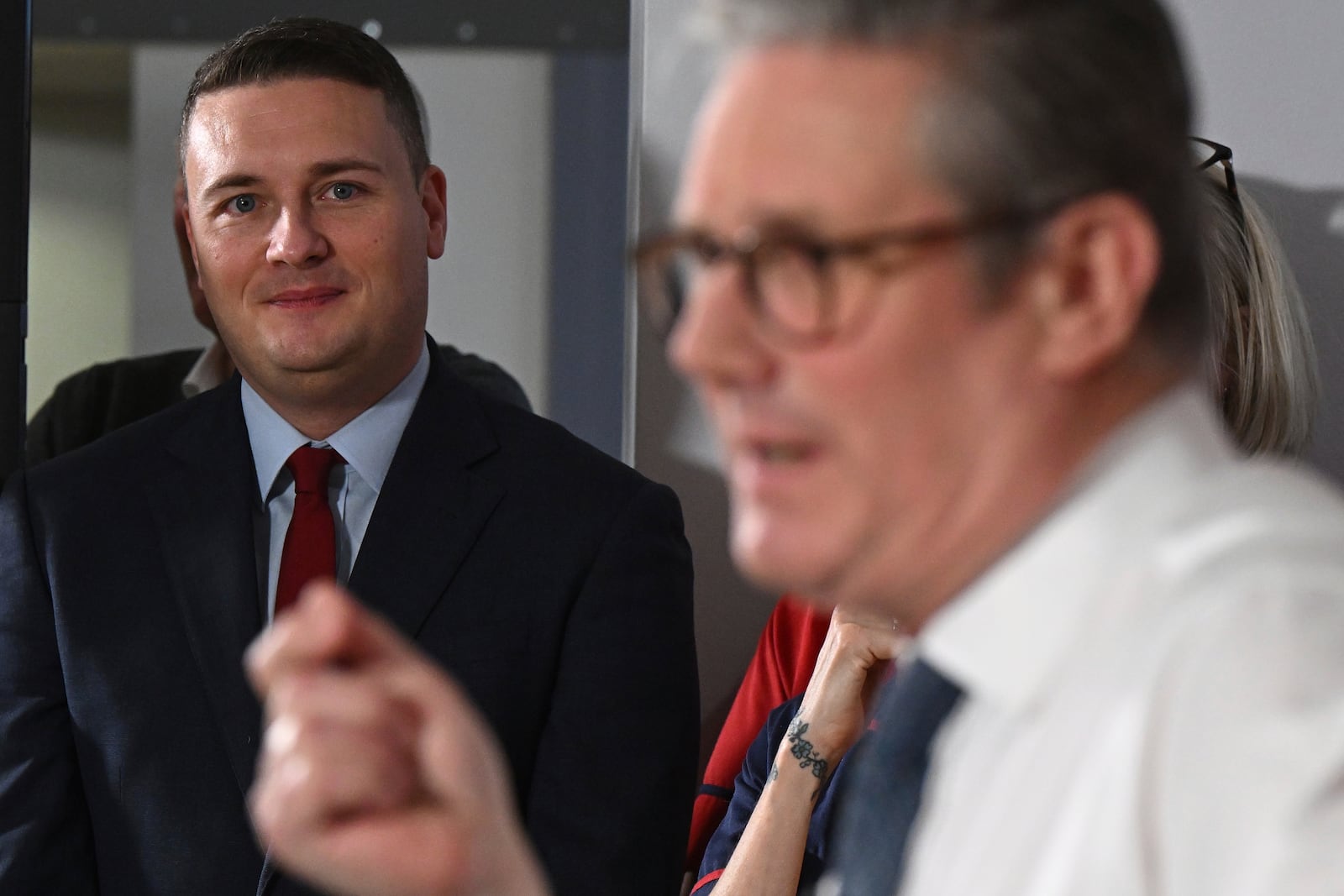 Britain's Health Secretary Wes Streeting, left, watches as Britain's Prime Minister Keir Starmer gives a speech on reducing NHS wait times as he visits a healthcare provider in Surrey, England, Monday, Jan. 6, 2025, (Leon Neal/Pool Photo via AP)