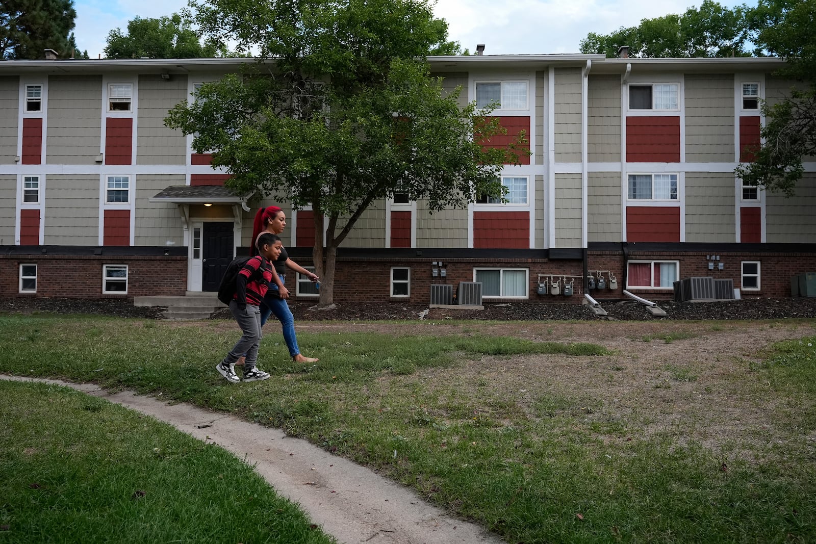 Dylan, left, is walked to school by his mother Gabriela Ramírez, Thursday, Aug. 29, 2024, in Aurora, Colo. (AP Photo/Godofredo A. Vásquez)