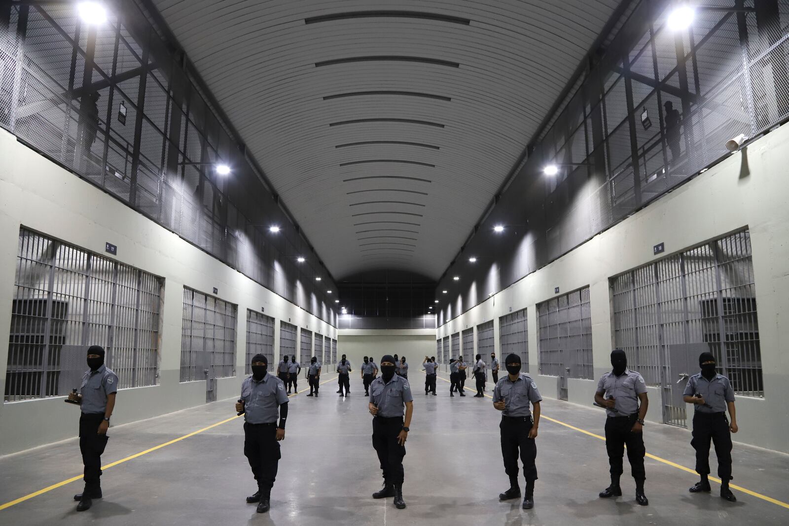 FILE - Prison guards stand outside holding cells during a media tour of the Terrorism Confinement Center, or CECOT, in Tecoluca, El Salvador, Feb. 2, 2023. (AP Photo/Salvador Melendez, File)