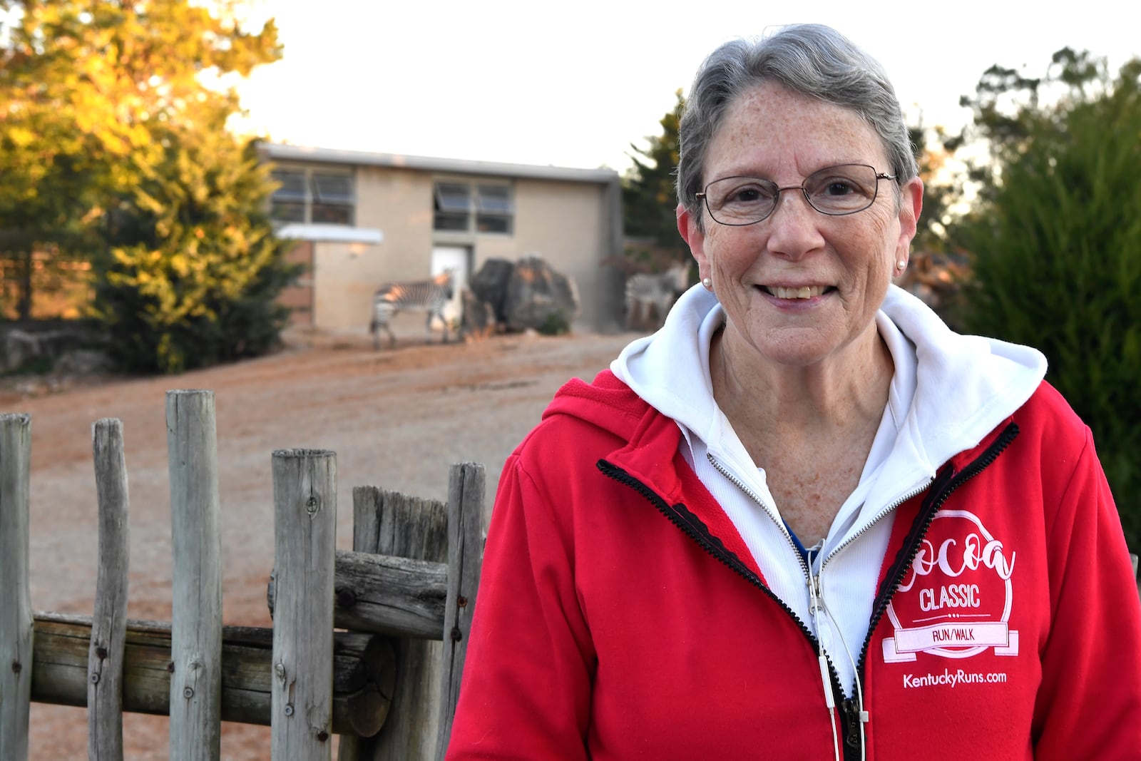 Janet Rapp, a member of the Get Healthy Walking Club stands in front of the zebra enclosure during the early morning at the Louisville Zoo in Louisville, Ky., Friday, Oct. 18, 2024. (AP Photo/Timothy D. Easley)