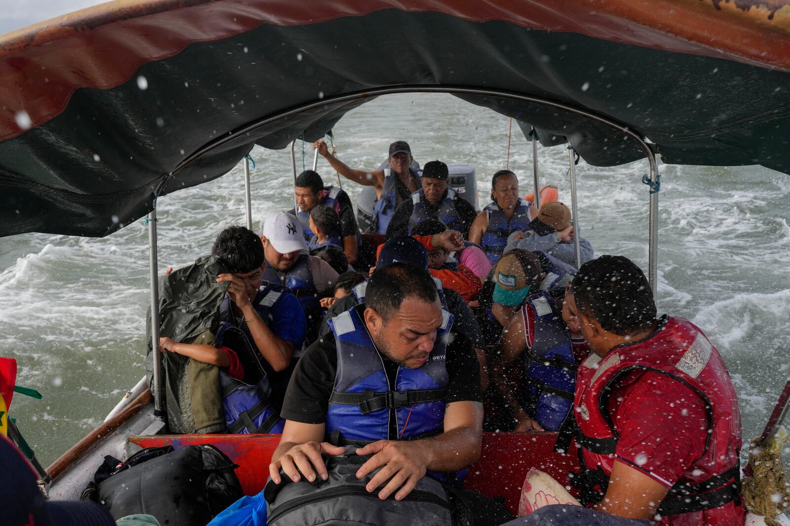 Luis Sanchez, center, sits with other Venezuelan migrants on a boat leaving Gardi Sugdub on Panama's Caribbean coast, Sunday, Feb. 23, 2025, after giving up hopes of reaching the U.S. while in southern Mexico amid President Trump's crackdown on migration. (AP Photo/Matias Delacroix)