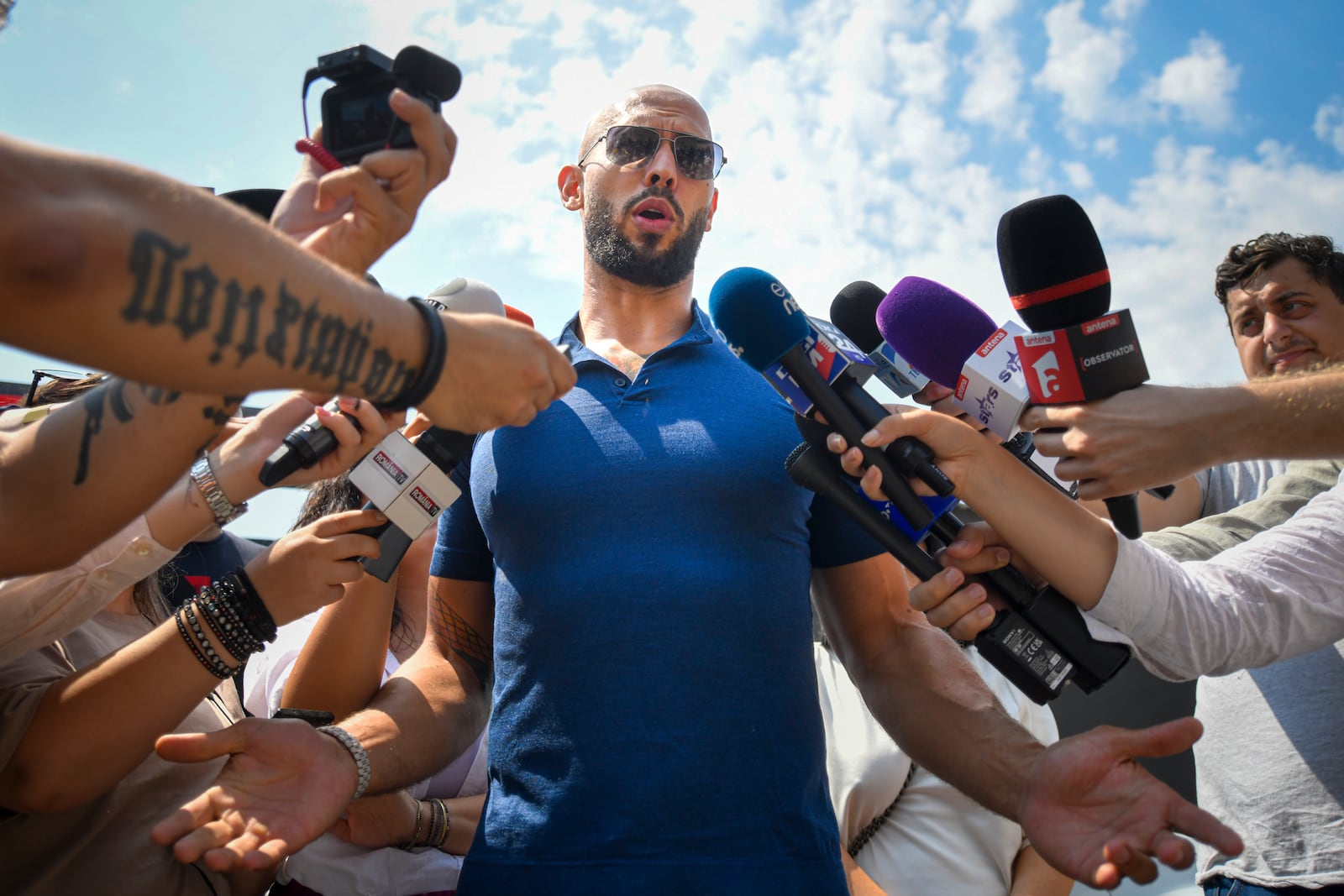 Andrew Tate speaks to media after being released from house arrest and put under judicial control measures, on the outskirts of Bucharest, Romania, Friday, Aug. 4, 2023. Andrew Tate, the divisive internet influencer who is charged in Romania with rape, human trafficking, and forming a criminal gang to sexually exploit women, won an appeal on Friday alongside his brother to be released from house arrest and will instead be put under judicial control measures, his spokesperson said. (AP Photo/Alexandru Dobre)