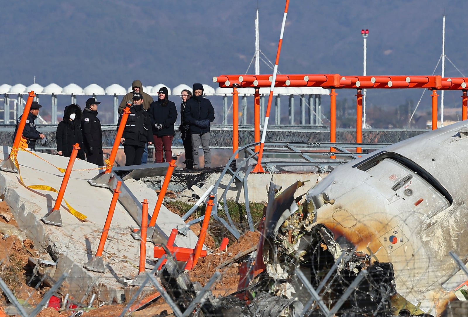 FILE - Experts from the U.S. National Transportation Safety Board (NTSB) and joint investigation team between the U.S. and South Korea check the site of a plane crash at Muan International Airport in Muan, South Korea, Dec. 31, 2024. (Son Hyung-joo/Yonhap via AP, File)