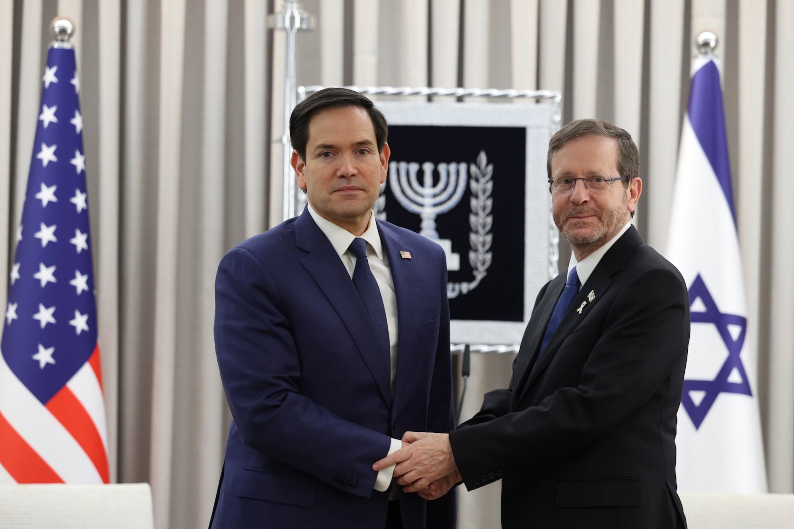 U.S. Secretary of State Marco Rubio, left, shakes hands with Israeli President Isaac Herzog during their meeting in Jerusalem, Israel, Sunday Feb. 16, 2025. (Abir Sultan/Pool Photo via AP)